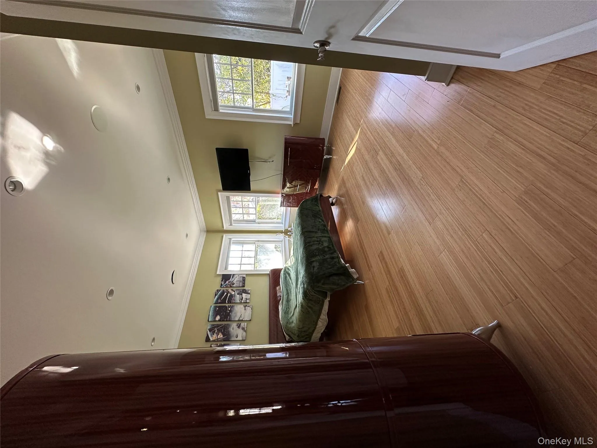Bedroom with Bamboo wood finished floors, crown and base molding and abundance of natural light Bedroom with Bamboo wood finished floors, crown and base molding and abundance of natural light