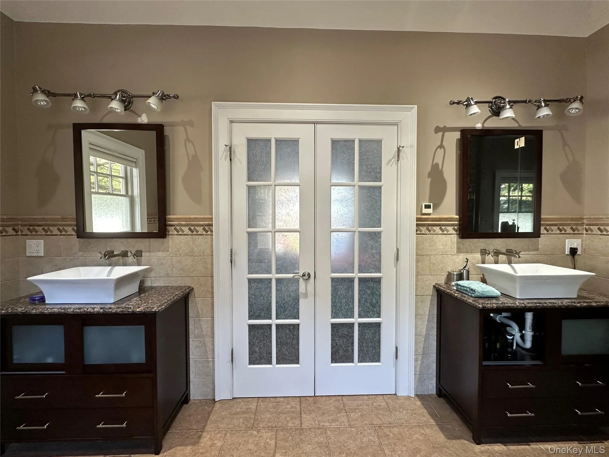 Full bath with Italian porcelain tile, two marble topped vanities, French doors, and radiant heat flooring Full bath with Italian porcelain tile, two marble topped vanities, French doors, and radiant heat flooring
