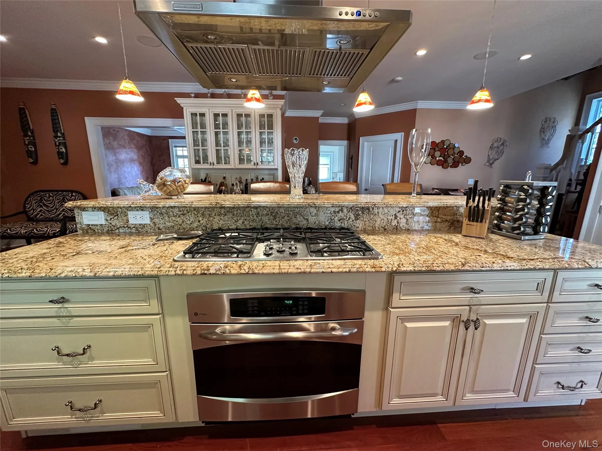 Kitchen featuring range hood, pendant lighting, recessed lighting, light granite counters, and stainless steel appliances Kitchen featuring range hood, pendant lighting, recessed lighting, light granite counters, and stainless steel appliances