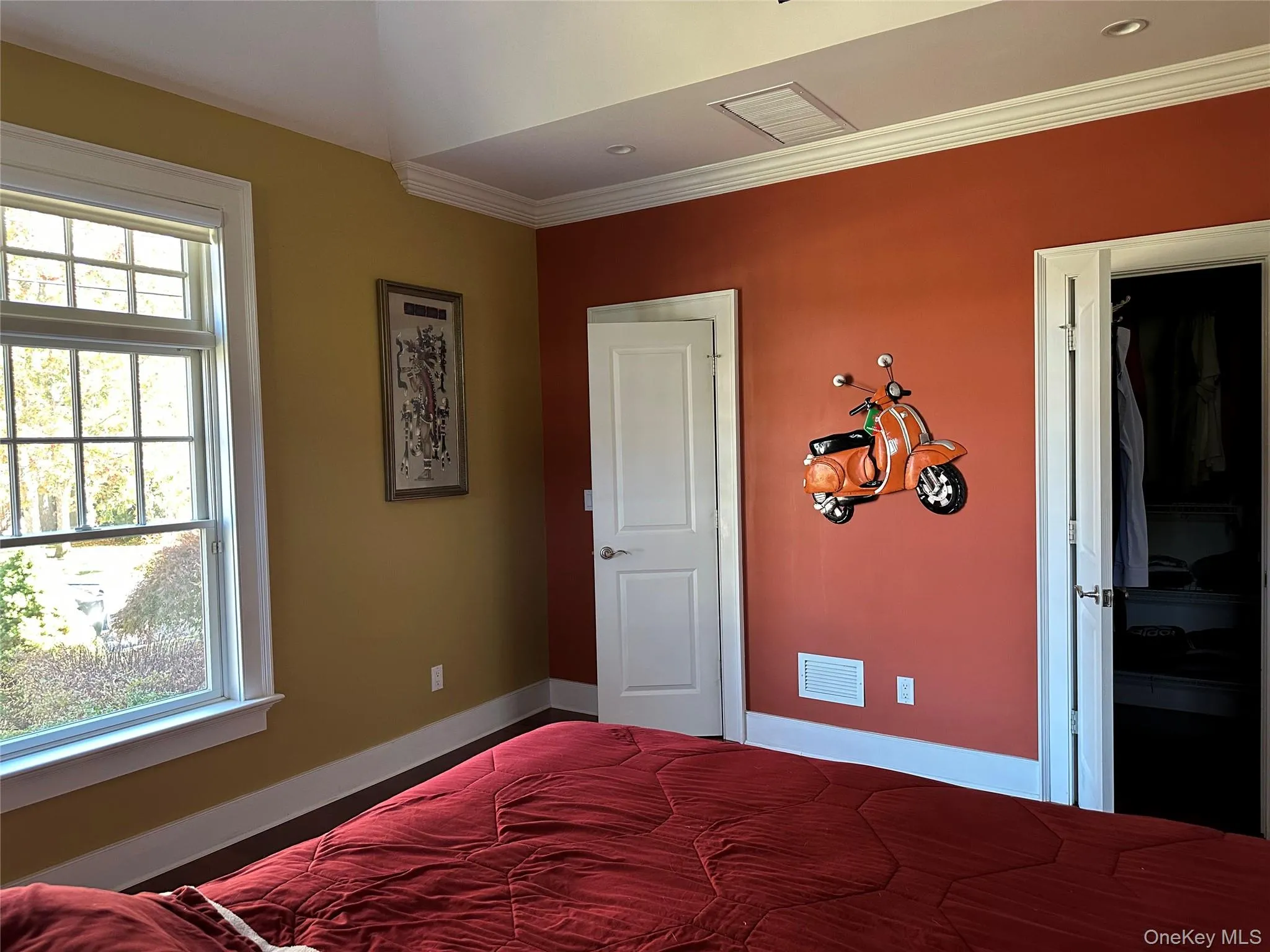 Primary bedroom with base and crown molding. @ generous sized California style walk in closets Primary bedroom with base and crown molding. @ generous sized California style walk in closets