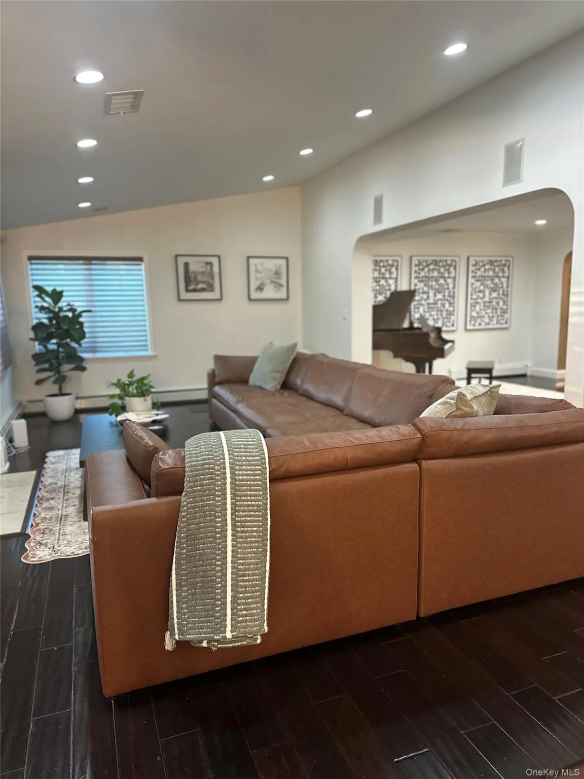 Living room featuring arched walkways, dark wood finished floors, recessed lighting, and lofted ceiling Living room featuring arched walkways, dark wood finished floors, recessed lighting, and lofted ceiling