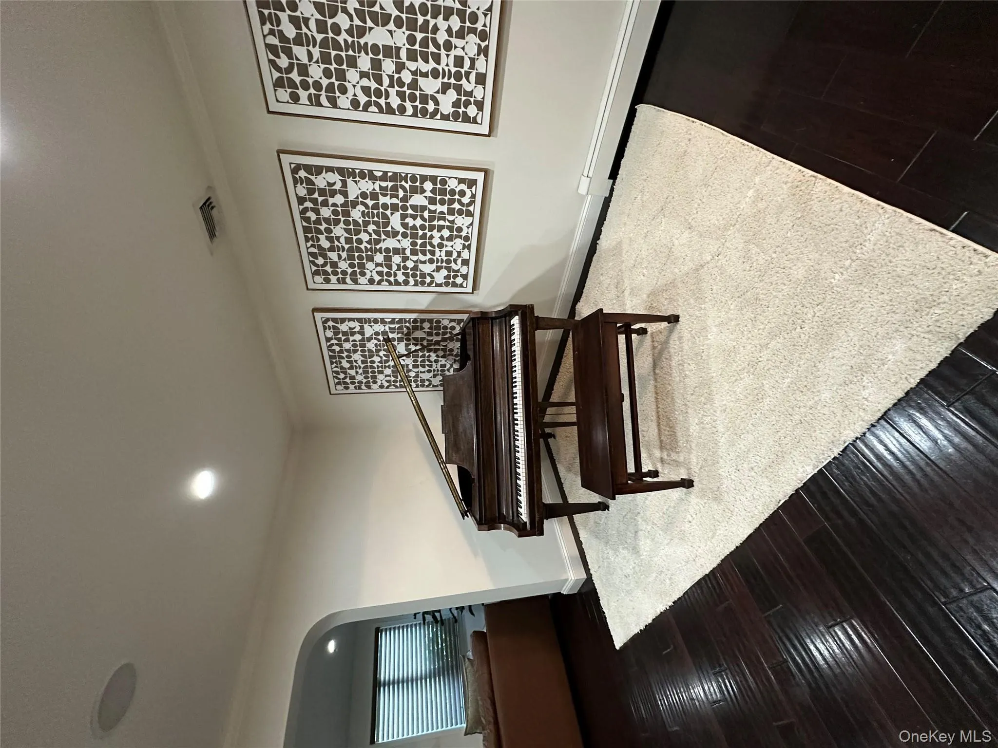 Living area with arched walkways, dark wood finished floors, ornamental molding, baseboard heating, and recessed lighting Living area with arched walkways, dark wood finished floors, ornamental molding, baseboard heating, and recessed lighting