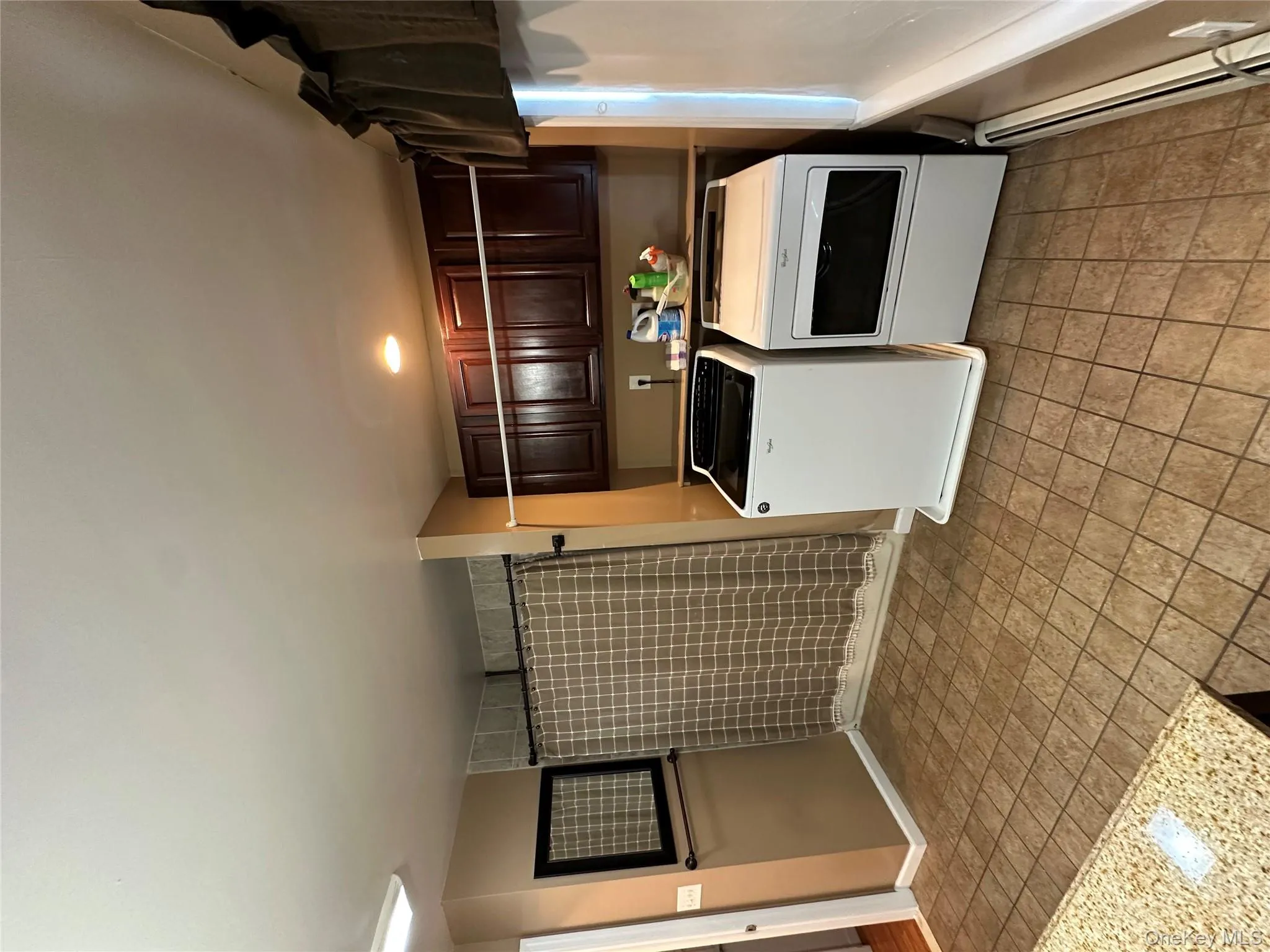 Washroom with washer and clothes dryer and a baseboard radiator Washroom with washer and clothes dryer and a baseboard radiator