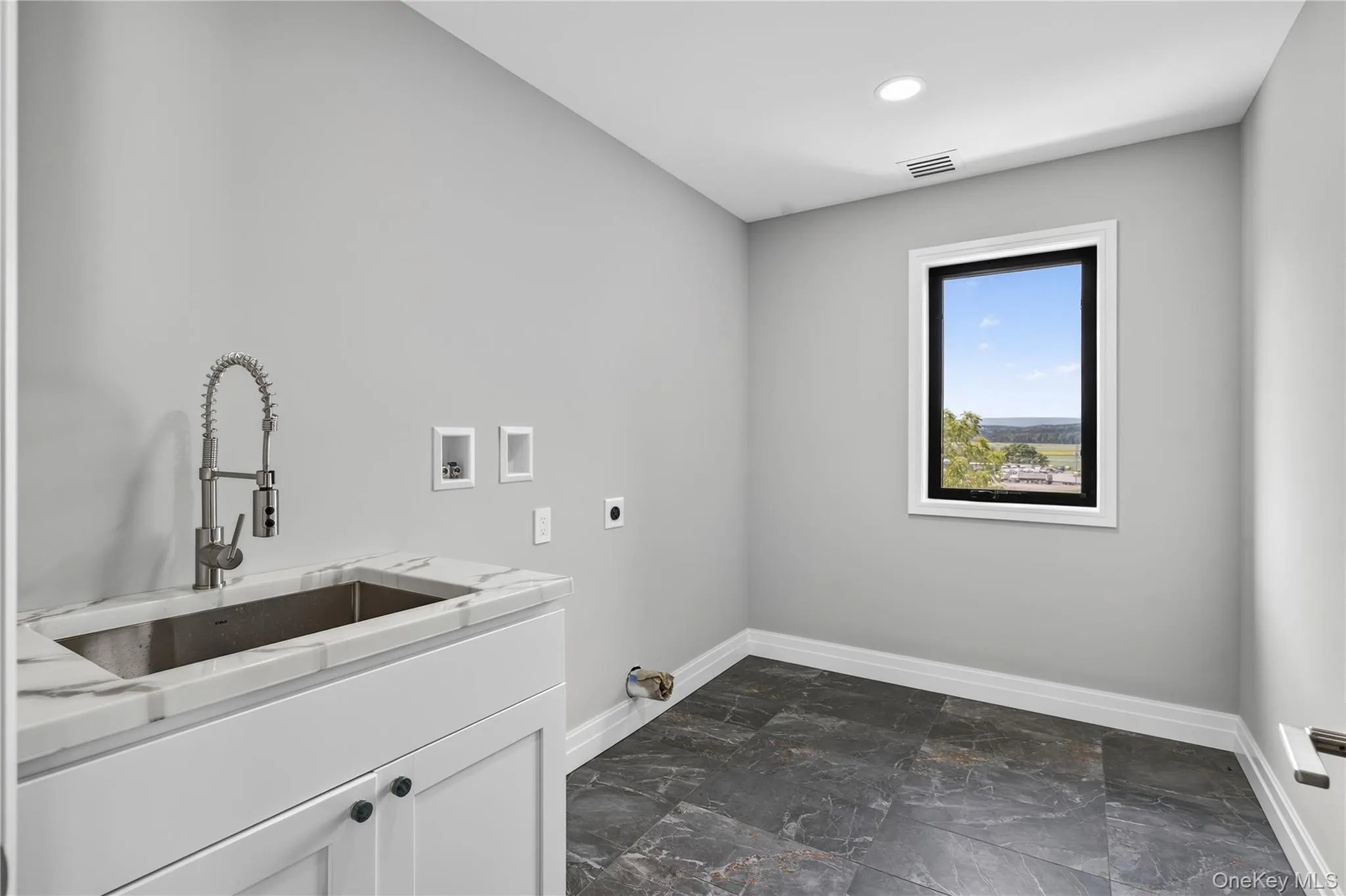 Laundry room featuring washer hookup, hookup for an electric dryer, cabinet space, and recessed lighting Laundry room featuring washer hookup, hookup for an electric dryer, cabinet space, and recessed lighting