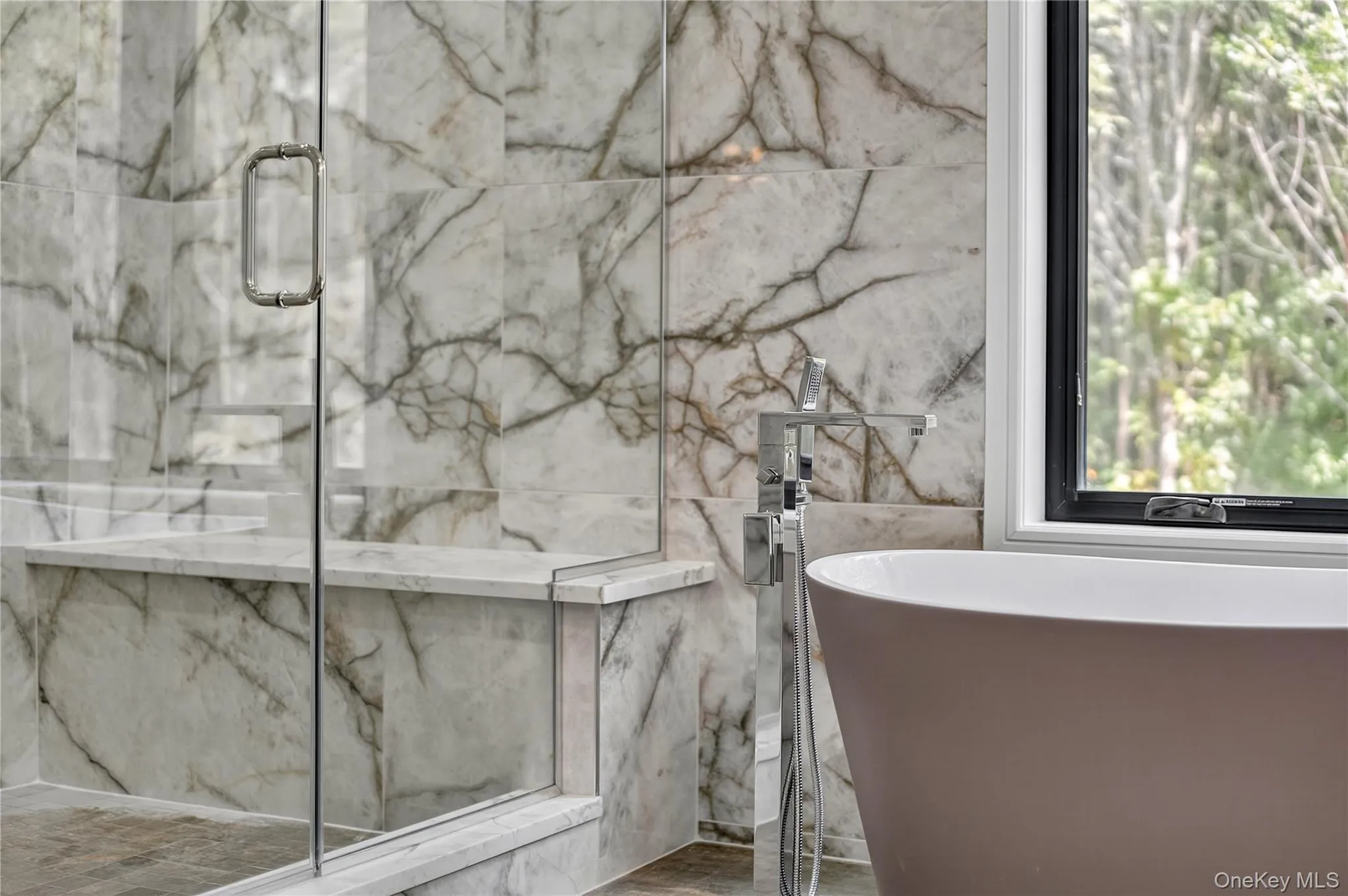 Bathroom with a freestanding bath and a marble finish shower Bathroom with a freestanding bath and a marble finish shower