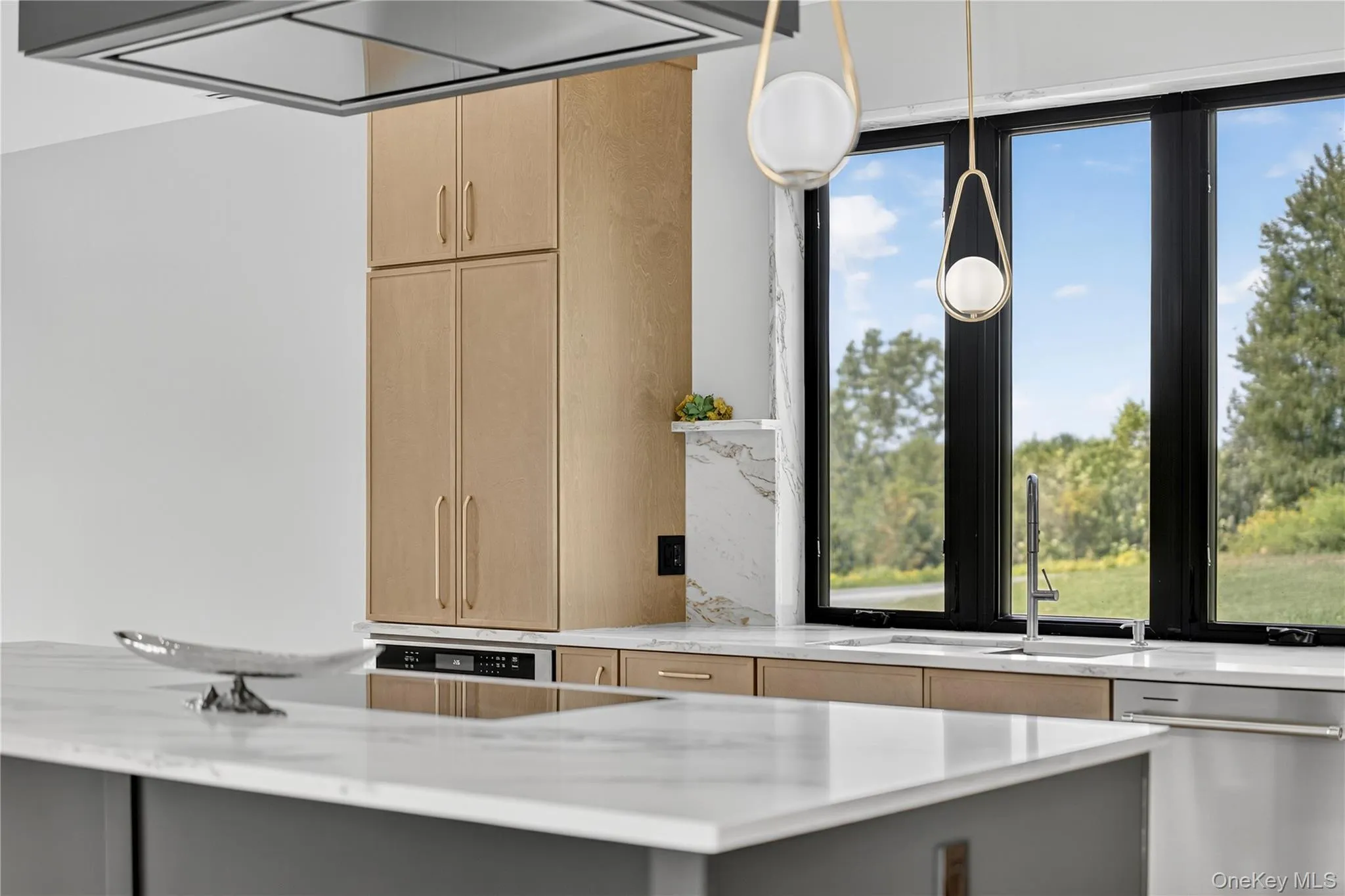 Kitchen with light brown cabinets, stainless steel dishwasher, light stone countertops, and gray cabinets Kitchen with light brown cabinets, stainless steel dishwasher, light stone countertops, and gray cabinets