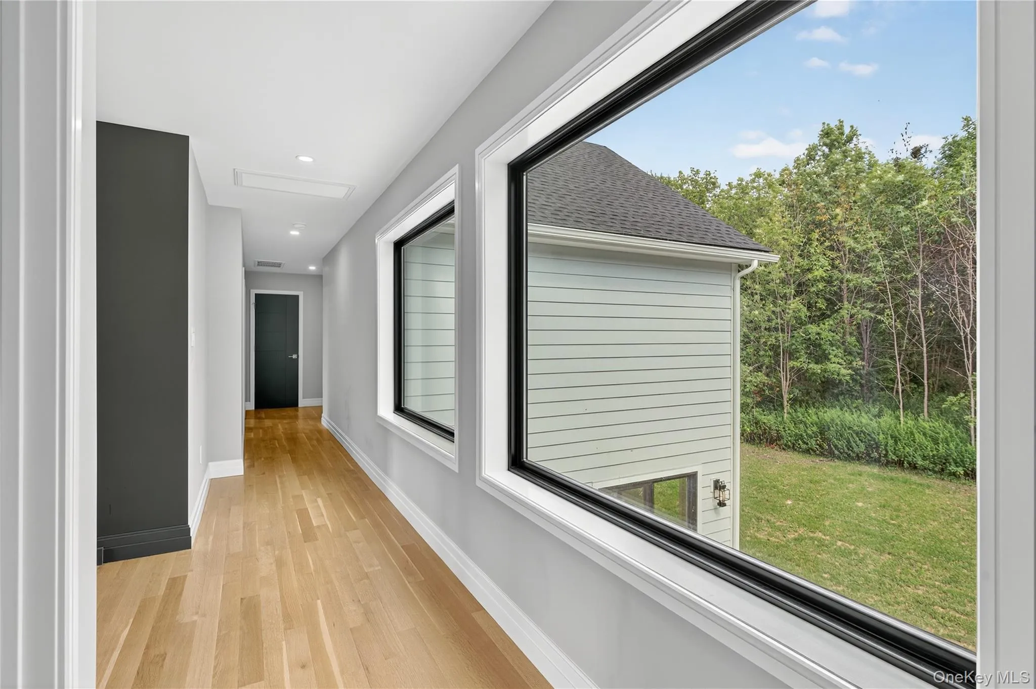 Hall with light wood finished floors and recessed lighting Hall with light wood finished floors and recessed lighting