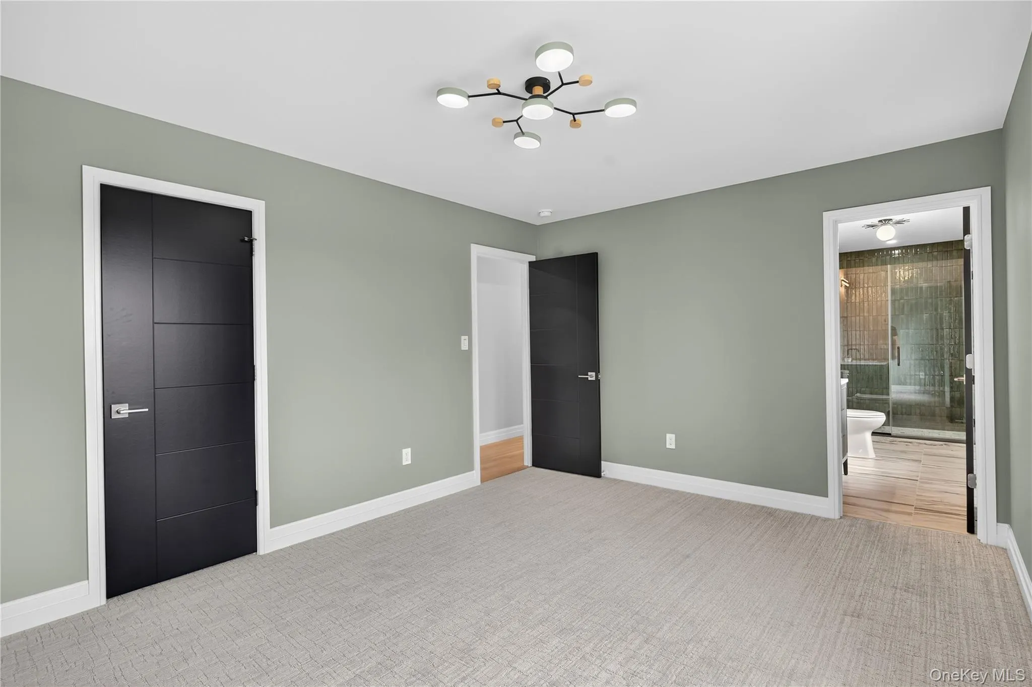 Unfurnished bedroom featuring ensuite bath, carpet flooring, and a chandelier Unfurnished bedroom featuring ensuite bath, carpet flooring, and a chandelier
