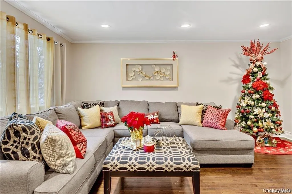 Living room with ornamental molding, wood finished floors, and recessed lighting Living room with ornamental molding, wood finished floors, and recessed lighting