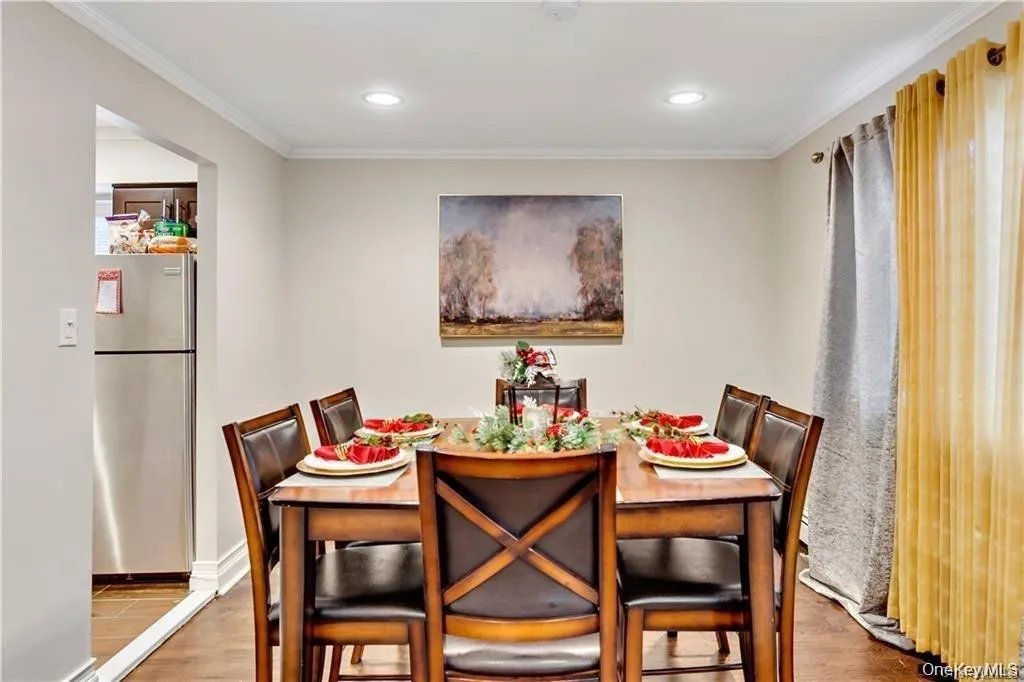 Dining area featuring wood finished floors, ornamental molding, and recessed lighting Dining area featuring wood finished floors, ornamental molding, and recessed lighting