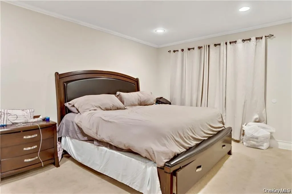 Bedroom featuring crown molding, light carpet, and recessed lighting Bedroom featuring crown molding, light carpet, and recessed lighting