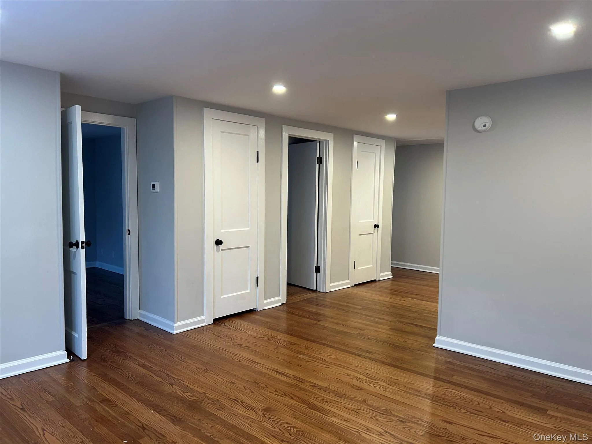 Living room featuring dark wood-style floors, plenty of natural light, recessed lighting, and baseboard heating Living room featuring dark wood-style floors, plenty of natural light, recessed lighting, and baseboard heating