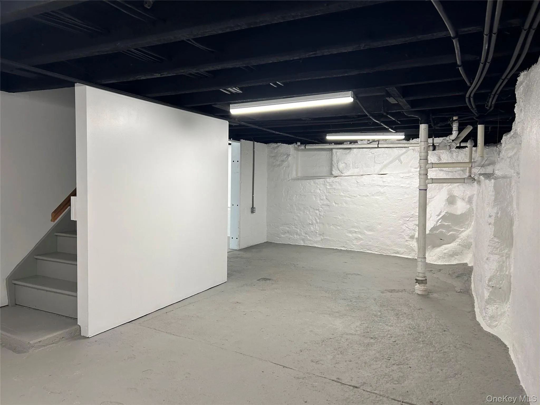 Unfinished basement featuring stairs Unfinished basement featuring stairs