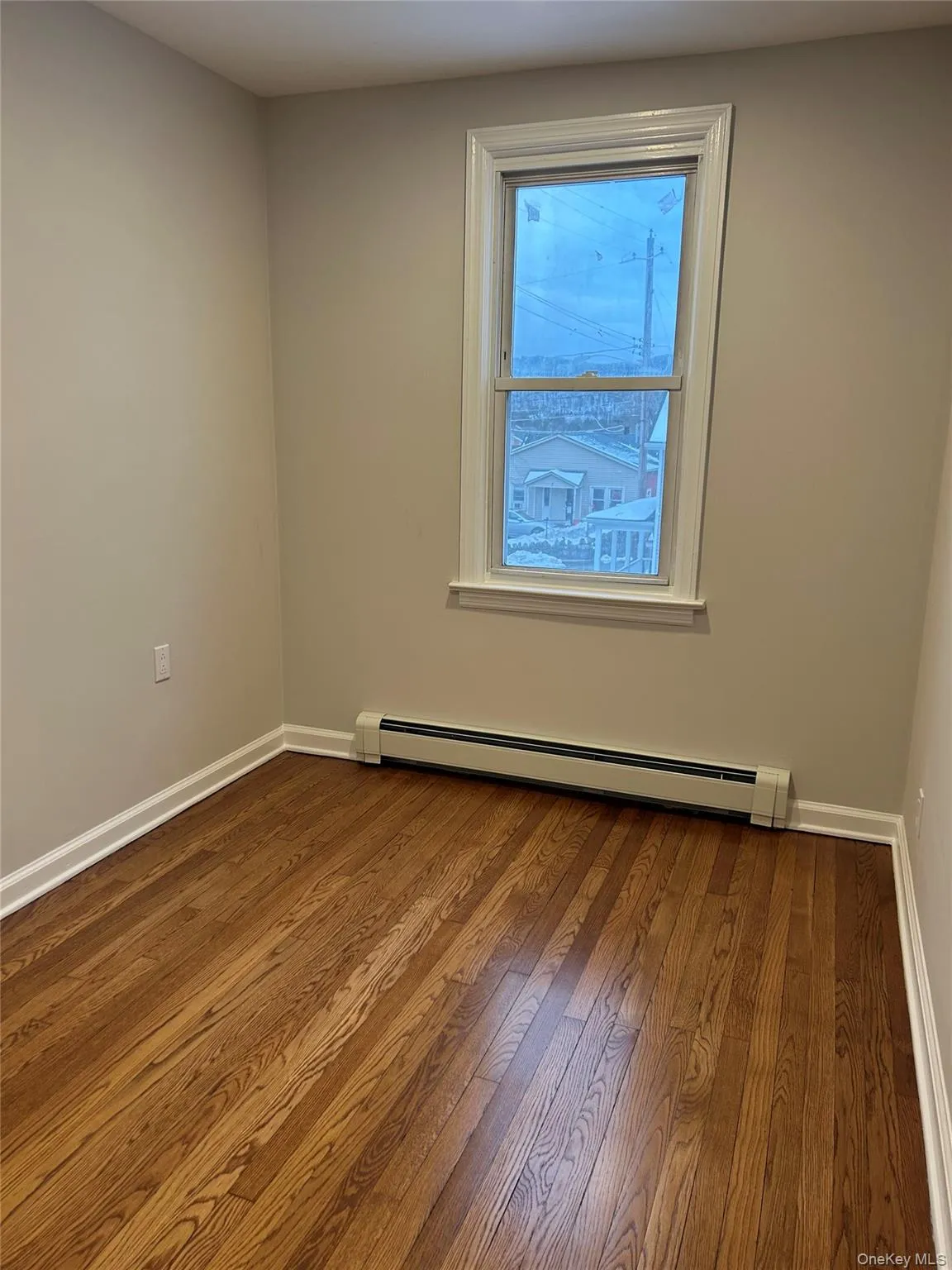 Bedroom with baseboard heating and dark wood-type flooring Bedroom with baseboard heating and dark wood-type flooring