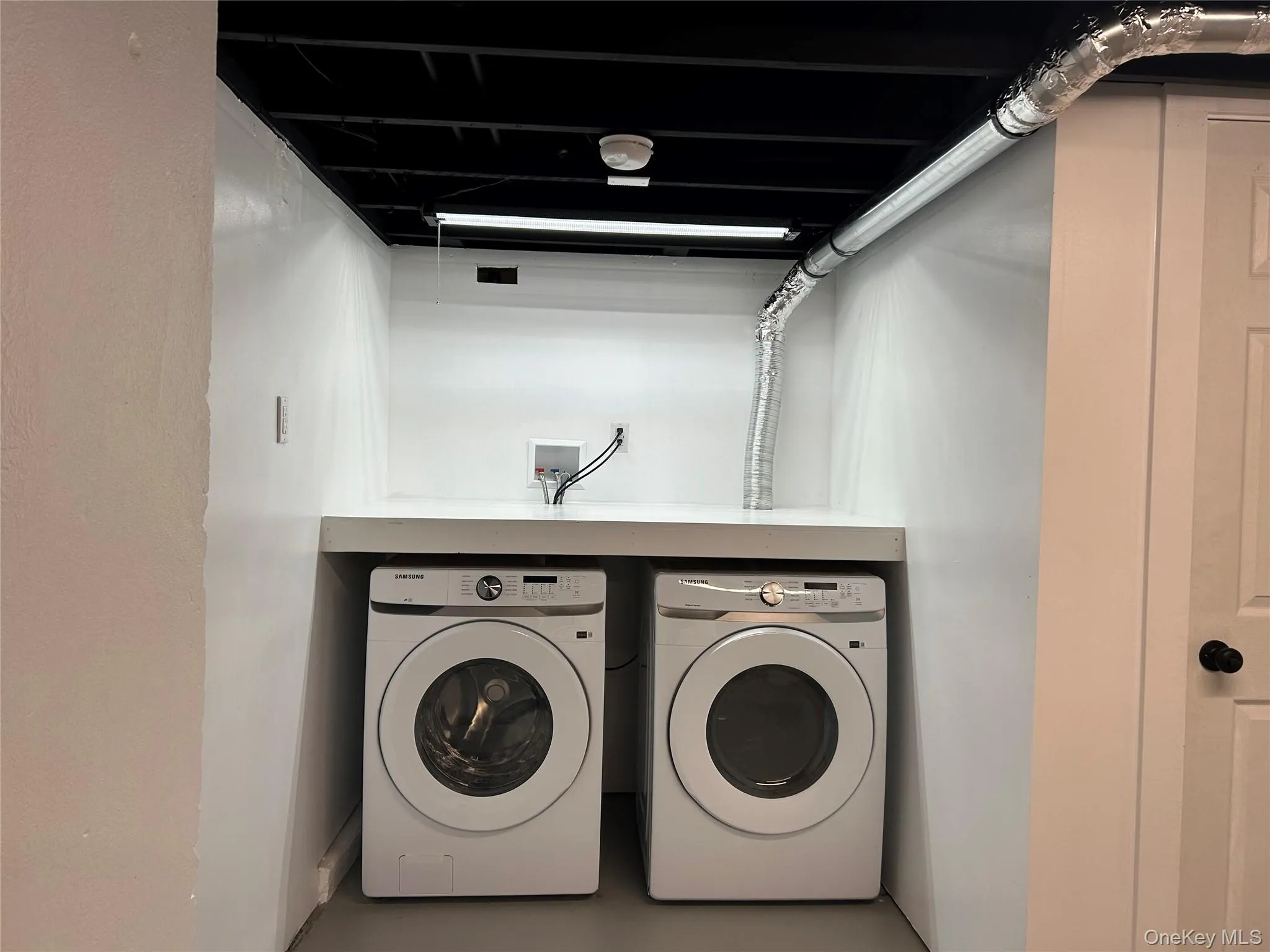 Washroom with washer and dryer and finished concrete flooring Washroom with washer and dryer and finished concrete flooring