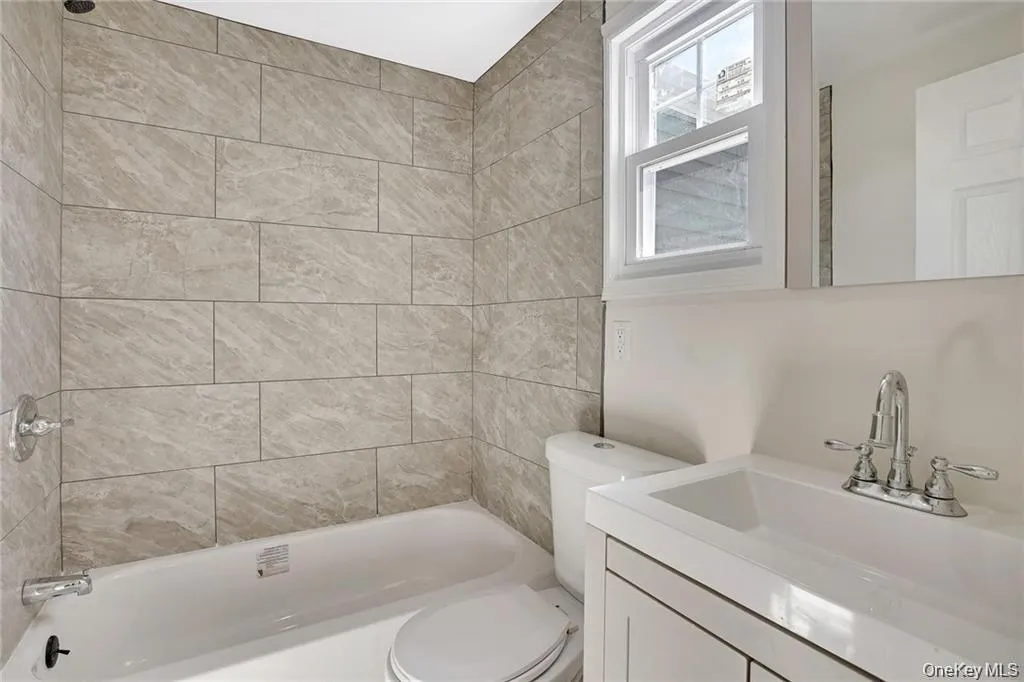 Well-appointed bathroom showcasing a tiled tub/shower and updated vanity. Well-appointed bathroom showcasing a tiled tub/shower and updated vanity.