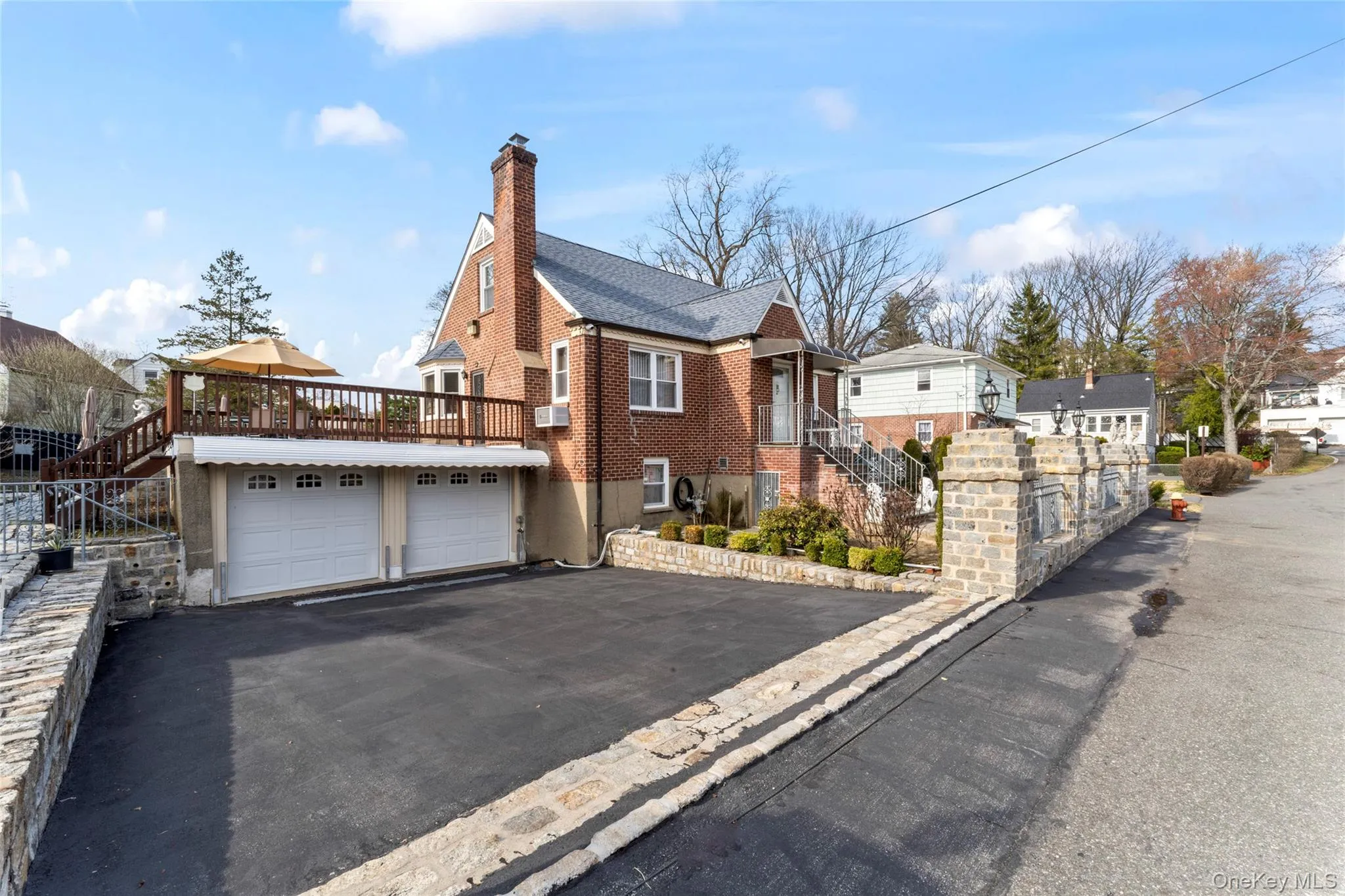 View of front of home featuring asphalt driveway, a chimney, a garage, a residential view, and brick siding View of front of home featuring asphalt driveway, a chimney, a garage, a residential view, and brick siding