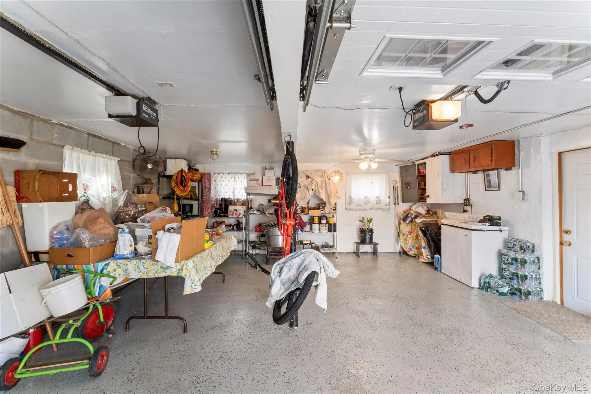 Heated 2 Car Garage with with Freezer and a garage door opener~Unblemished Garage Floor~3 Full Window~Door to Walk in Unit~Ceiling Lighting Heated 2 Car Garage with with Freezer and a garage door opener~Unblemished Garage Floor~3 Full Window~Door to Walk in Unit~Ceiling Lighting