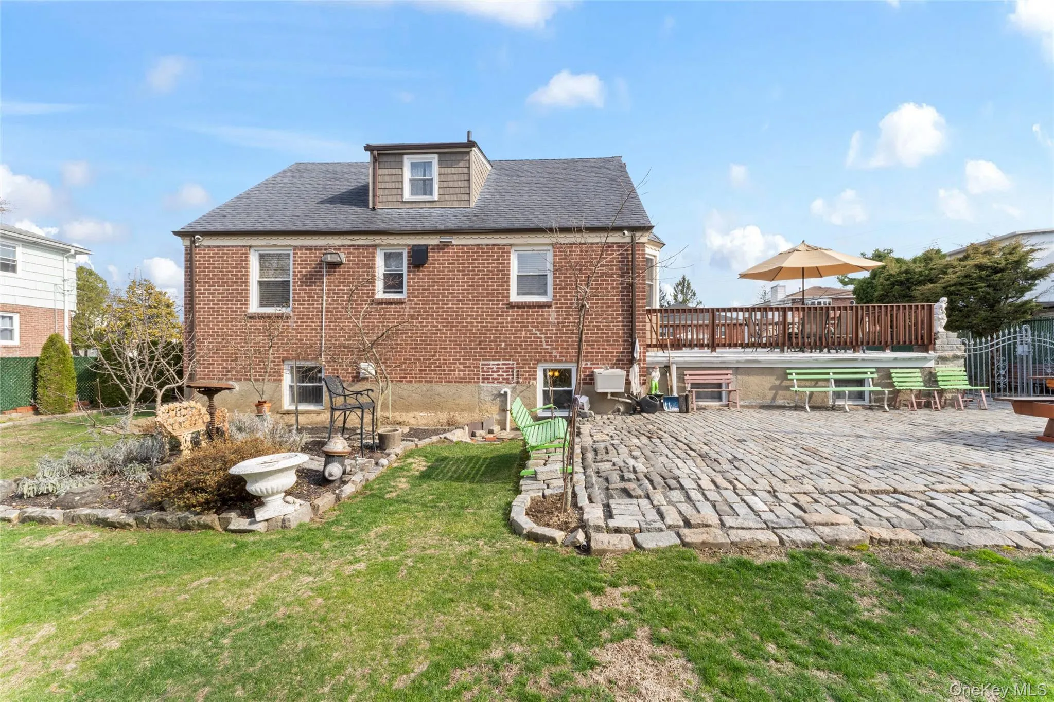 Back of house with a patio, brick siding, a shingled roof, and a yard Back of house with a patio, brick siding, a shingled roof, and a yard
