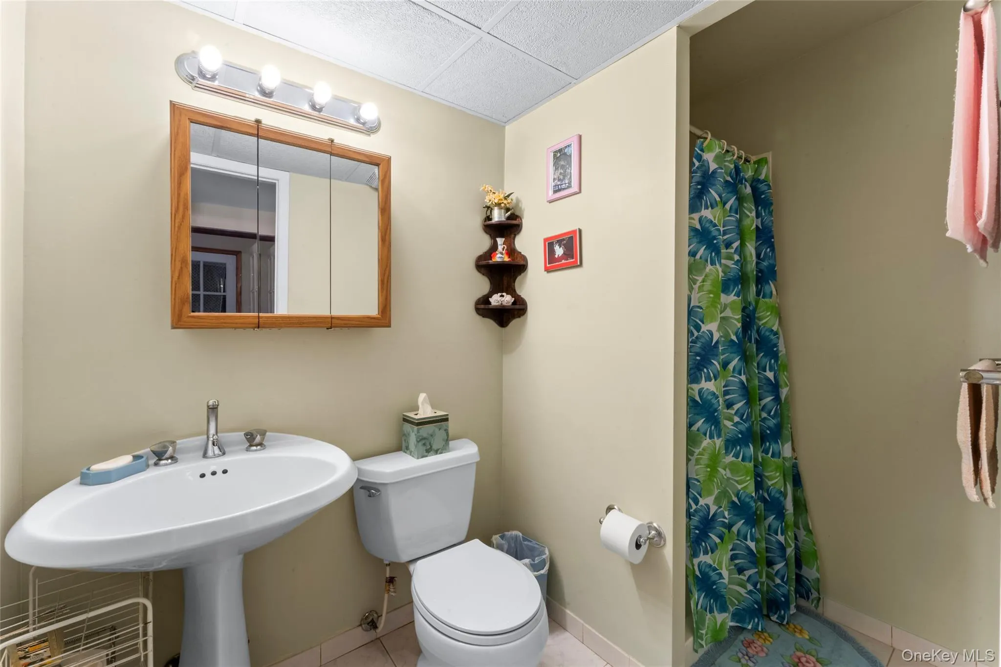 Full bath featuring a shower stall, a drop ceiling, and light tile patterned floors Full bath featuring a shower stall, a drop ceiling, and light tile patterned floors