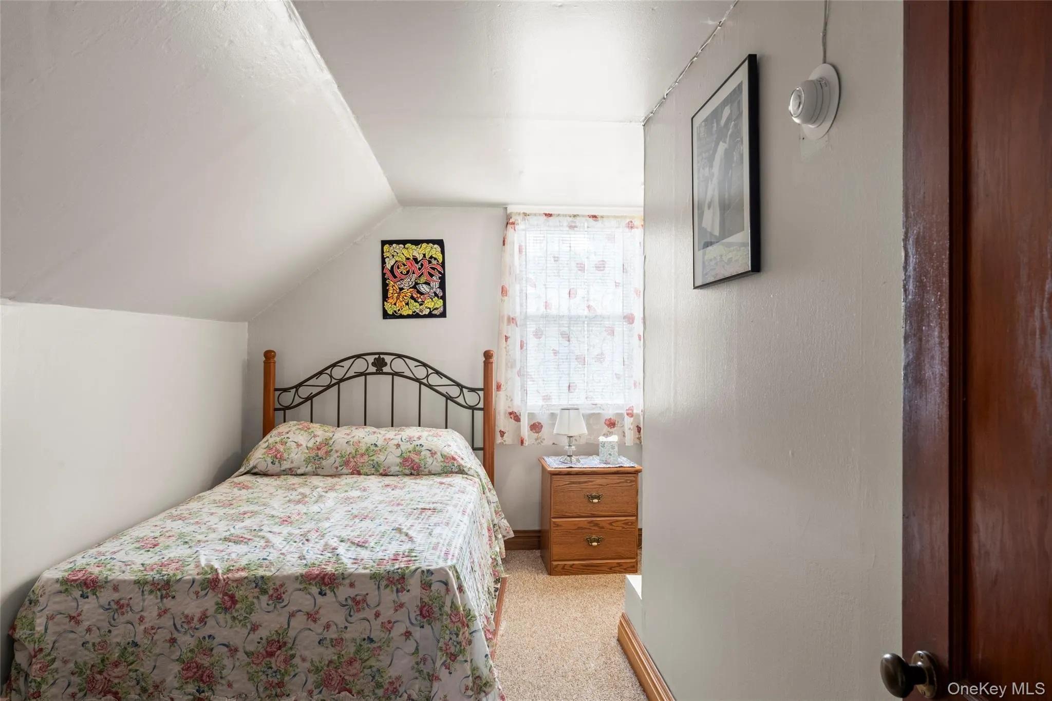 Bedroom featuring lofted ceiling and light colored carpet Bedroom featuring lofted ceiling and light colored carpet