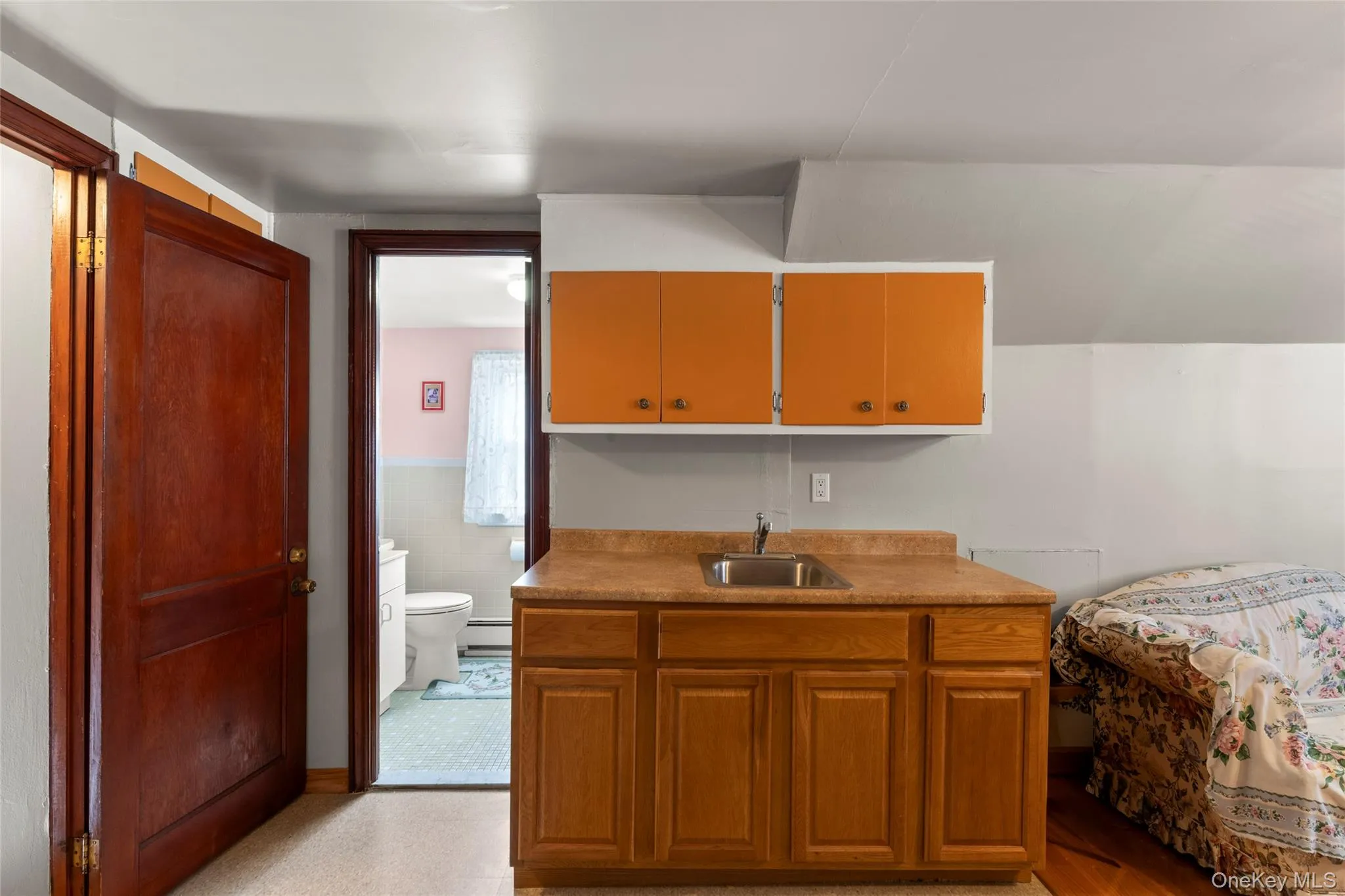 Bedroom with a wainscoted wall, tile walls, and baseboard heating Bedroom with a wainscoted wall, tile walls, and baseboard heating