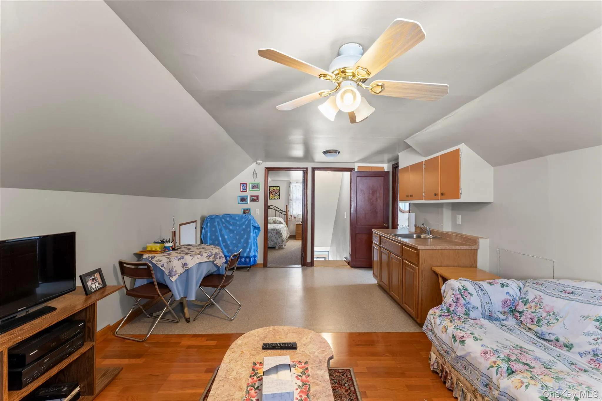 Bedroom featuring vaulted ceiling, a ceiling fan, and light wood finished floors Bedroom featuring vaulted ceiling, a ceiling fan, and light wood finished floors