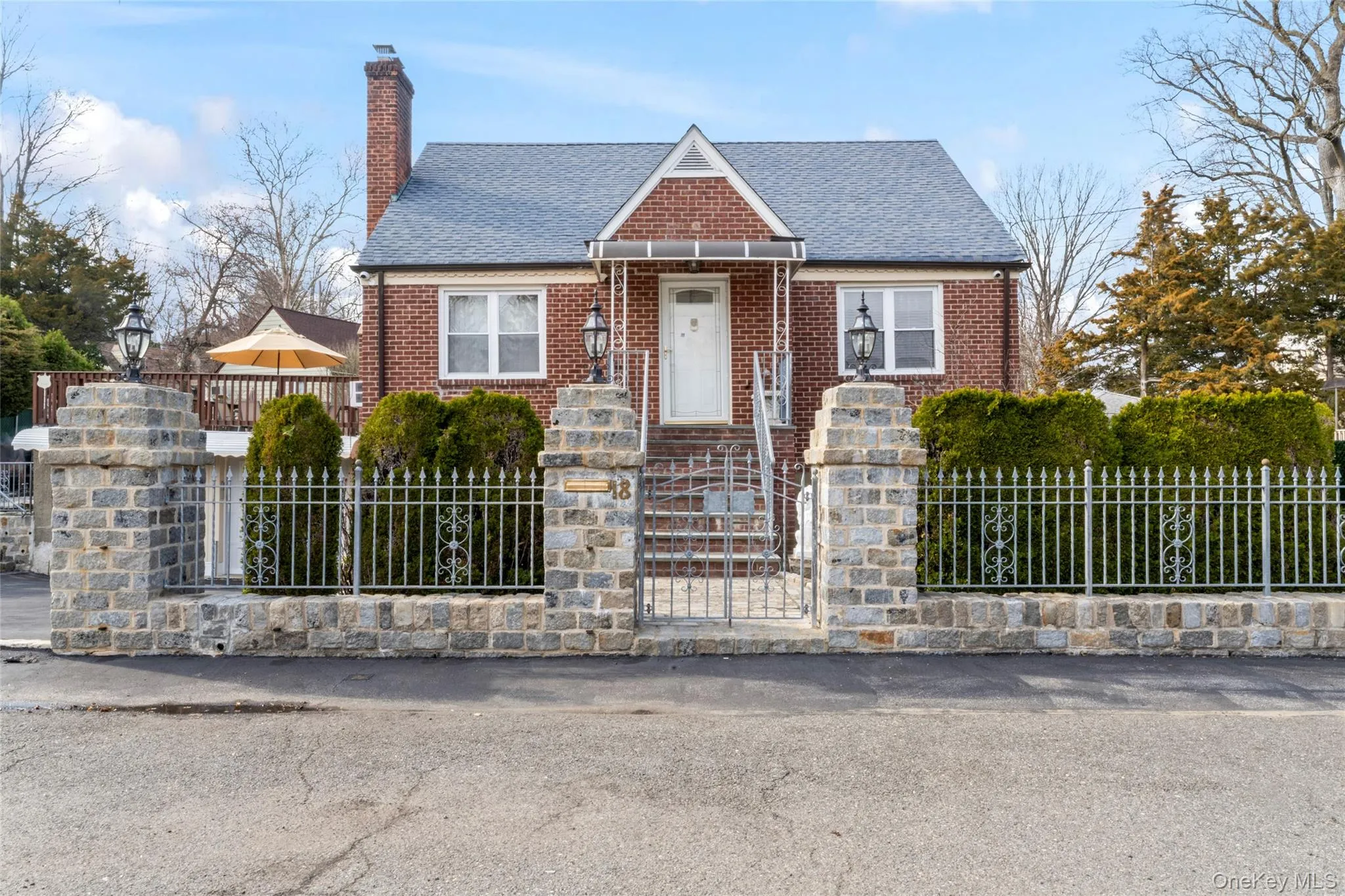 View of front of house featuring a fenced front yard, brick siding, a chimney, and a shingled roof View of front of house featuring a fenced front yard, brick siding, a chimney, and a shingled roof