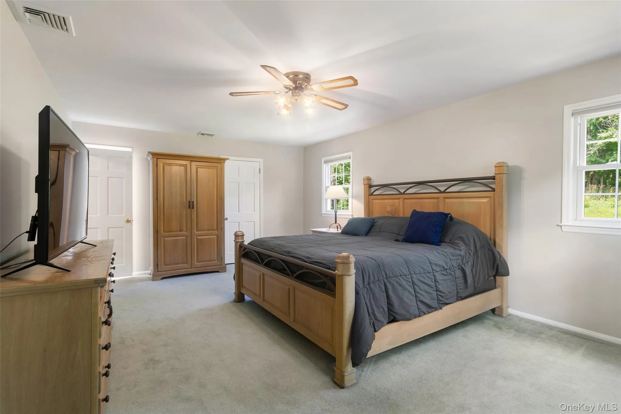 Primary spacious bedroom with carpeting and hardwood flooring underneath with walk in closet. Primary spacious bedroom with carpeting and hardwood flooring underneath with walk in closet.