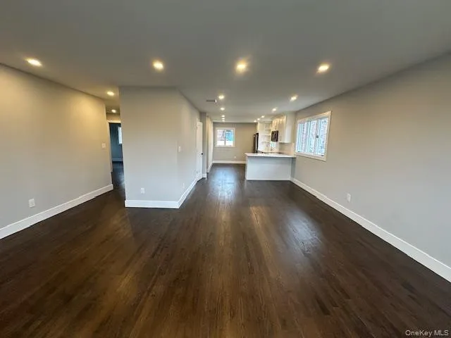 Unfurnished living room with dark wood finished floors and recessed lighting Unfurnished living room with dark wood finished floors and recessed lighting