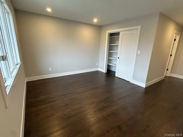 Unfurnished bedroom with dark wood-style flooring, a closet, and recessed lighting Unfurnished bedroom with dark wood-style flooring, a closet, and recessed lighting