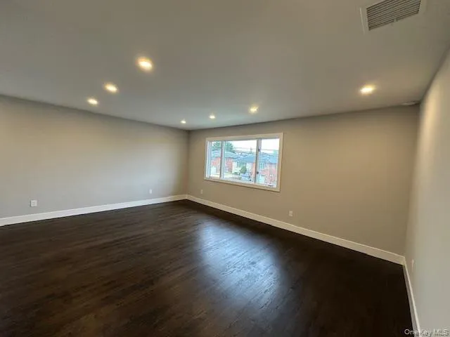 Living room featuring dark wood-style floors and recessed lighting Living room featuring dark wood-style floors and recessed lighting