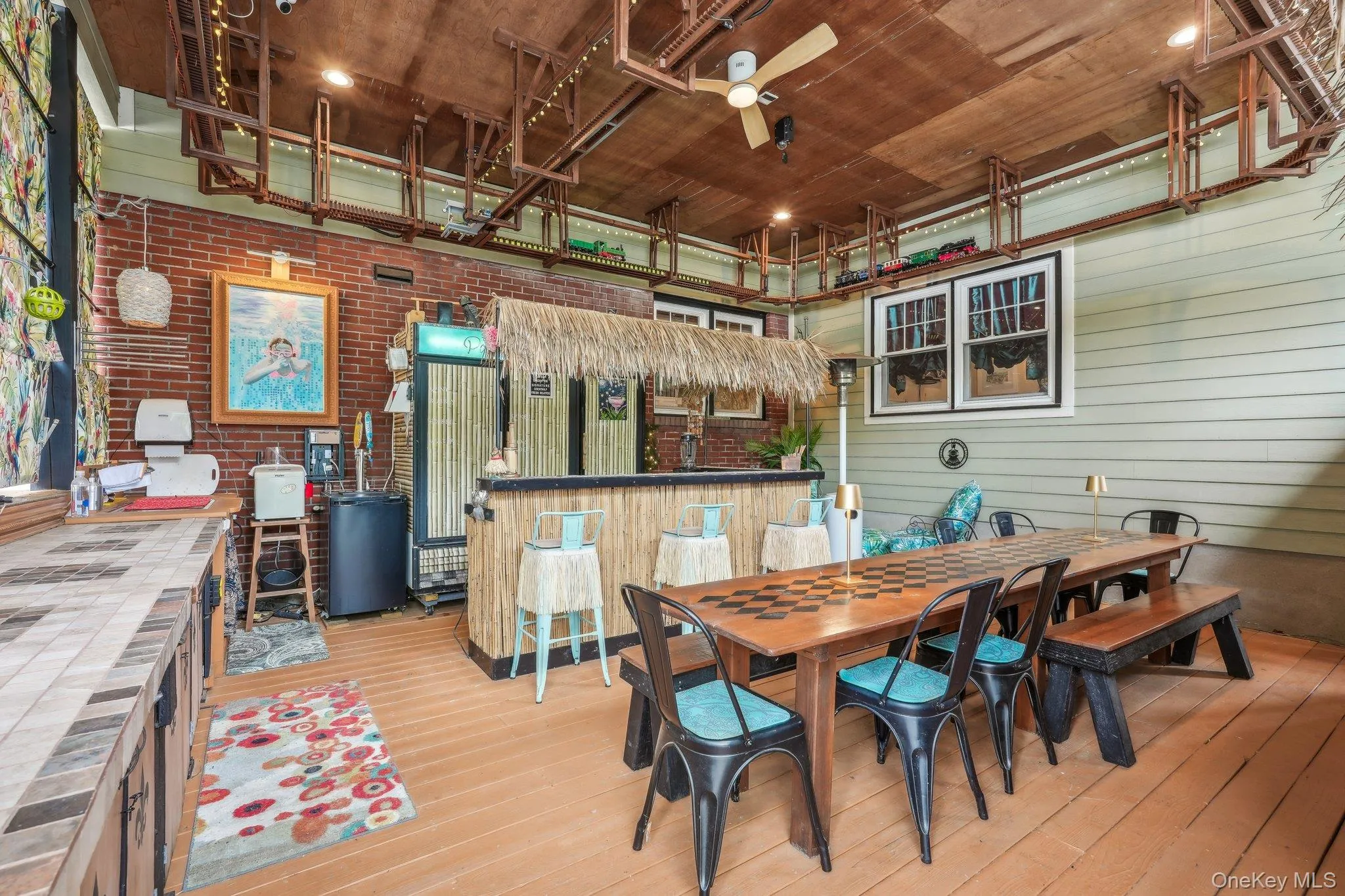 Tiki bar with refrigerator, kegerator, sink, speaker system and overhead train tracks Tiki bar with refrigerator, kegerator, sink, speaker system and overhead train tracks