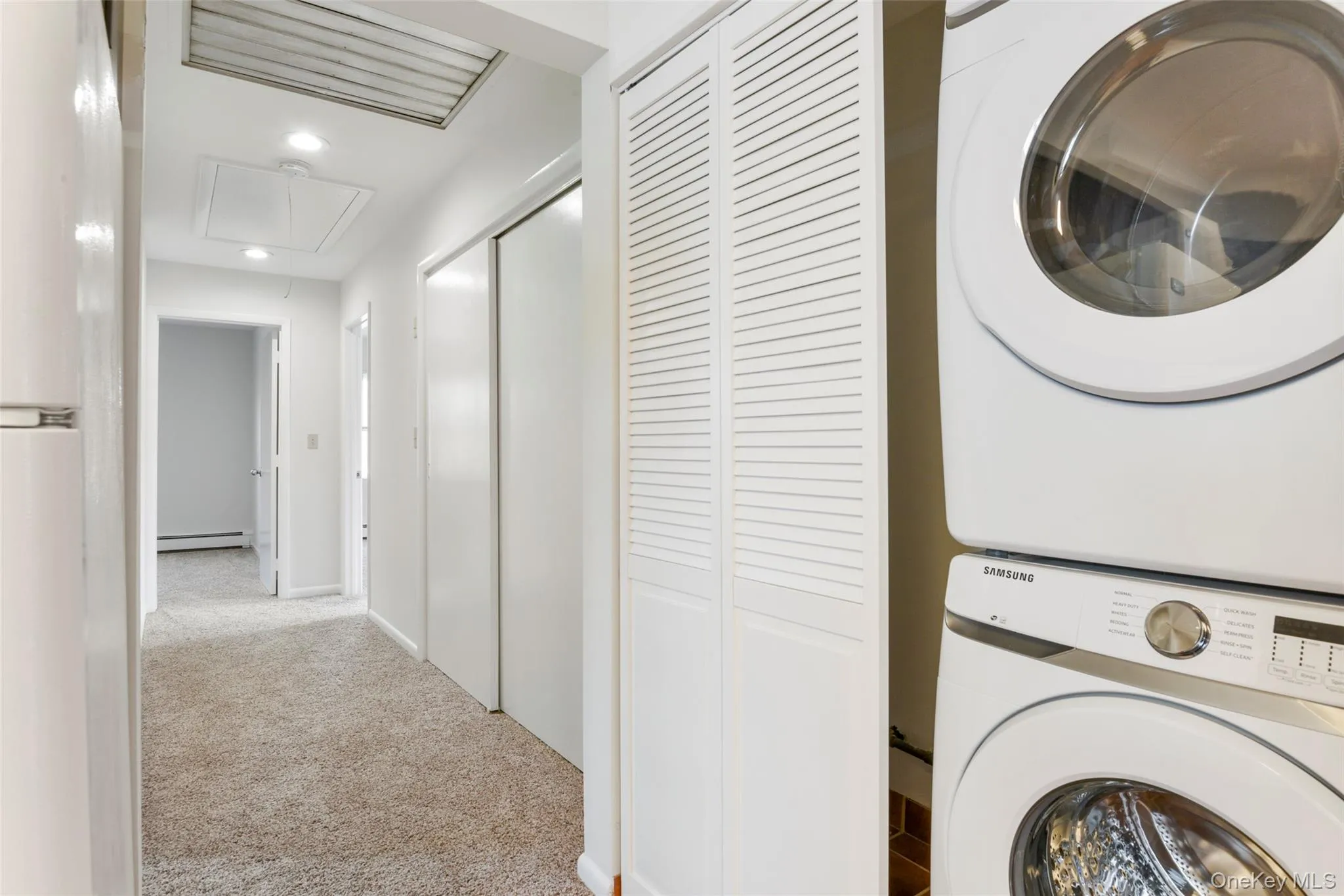View down hall with large double closet and stairs to huge attic space View down hall with large double closet and stairs to huge attic space