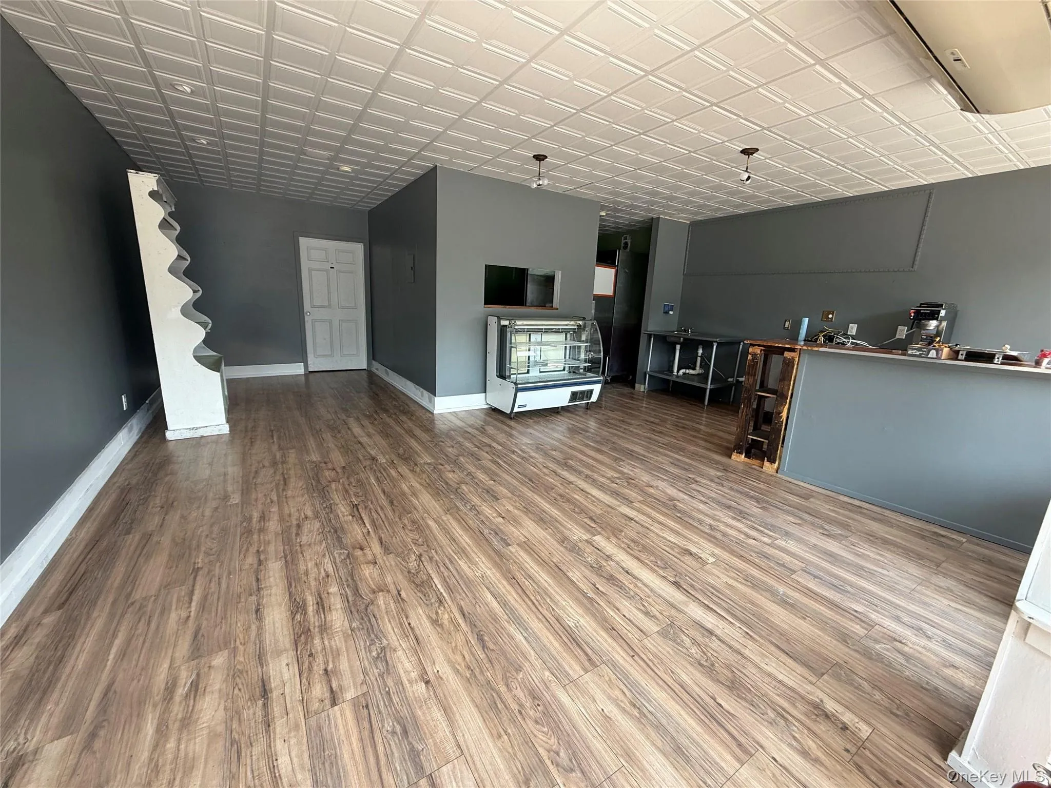 Unfurnished living room with wood finished floors and baseboards Unfurnished living room with wood finished floors and baseboards