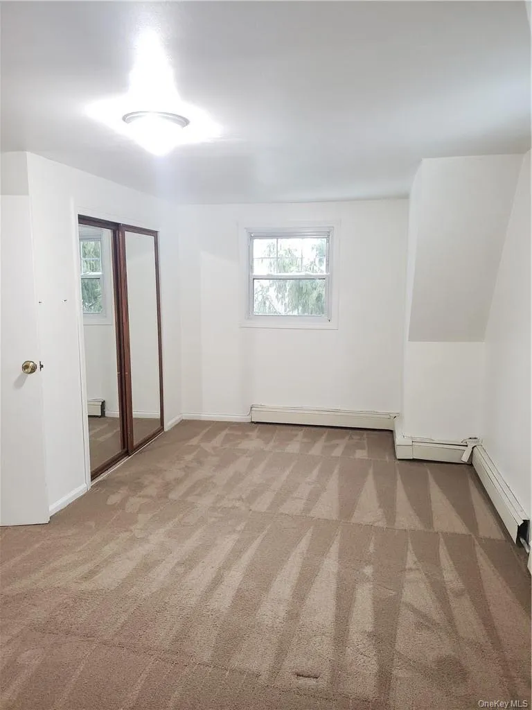 Unfurnished bedroom featuring light colored carpet, multiple windows, and a closet Unfurnished bedroom featuring light colored carpet, multiple windows, and a closet
