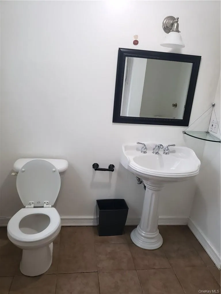 Half bath with toilet and tile patterned floors Half bath with toilet and tile patterned floors