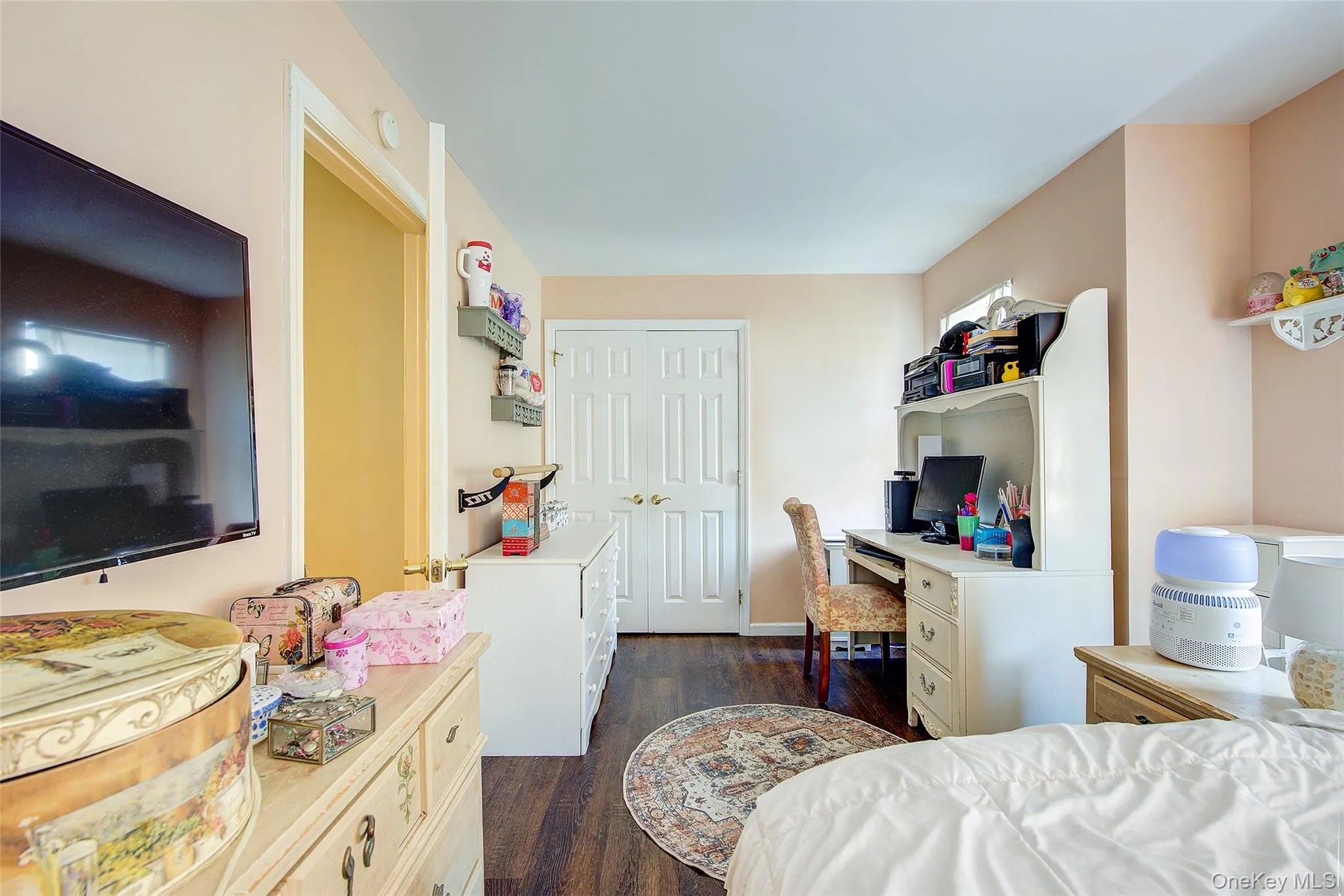 Bedroom with dark wood-type flooring, an office area, and a closet Bedroom with dark wood-type flooring, an office area, and a closet