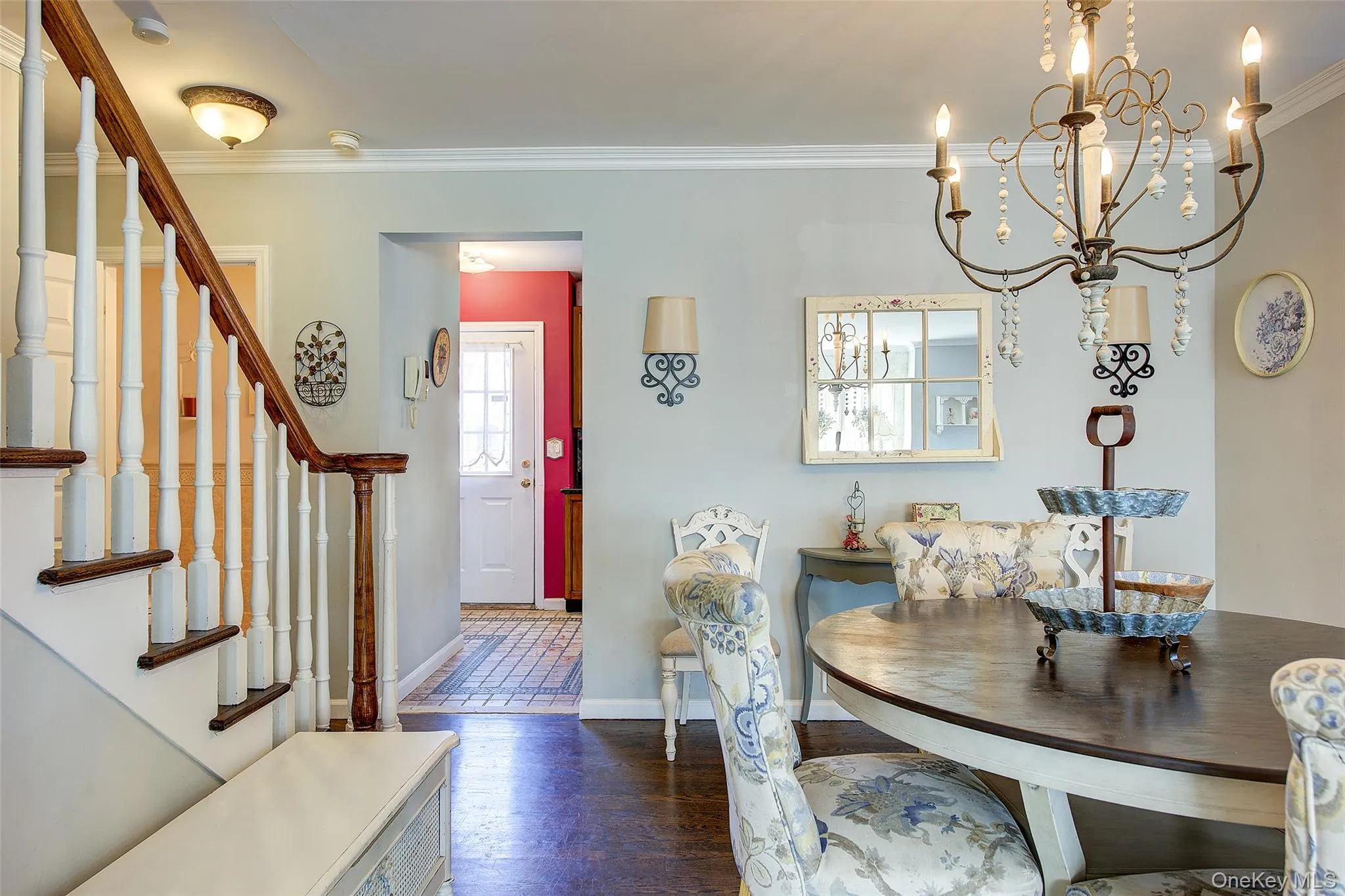 Dining room featuring ornamental molding, stairway, dark wood finished floors, and a chandelier Dining room featuring ornamental molding, stairway, dark wood finished floors, and a chandelier