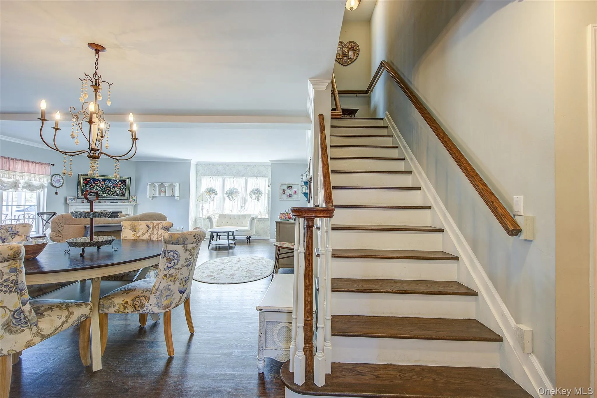 Stairway featuring wood finished floors, a chandelier, and crown molding Stairway featuring wood finished floors, a chandelier, and crown molding