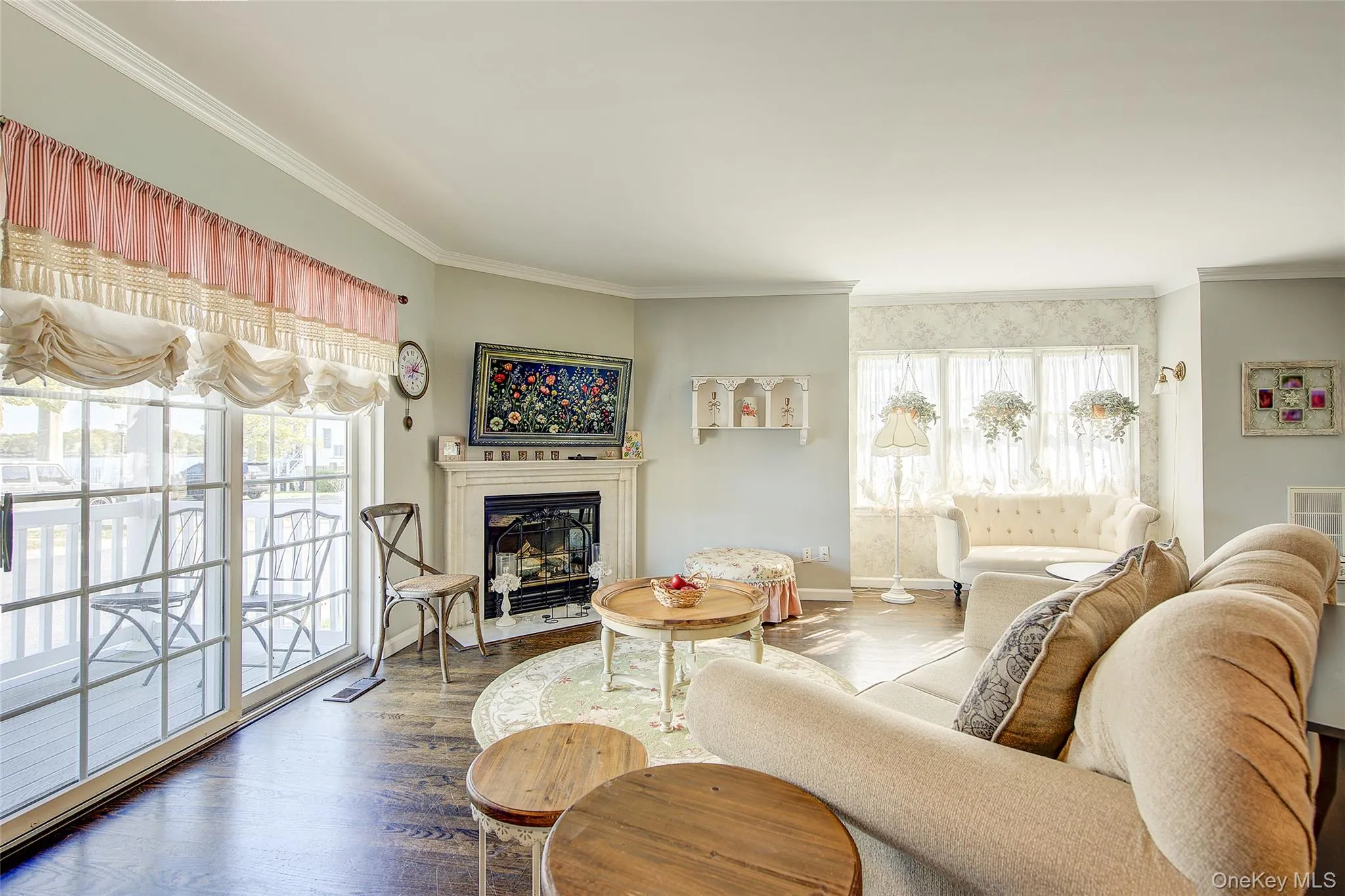 Living room with wood finished floors, ornamental molding, and a glass covered fireplace Living room with wood finished floors, ornamental molding, and a glass covered fireplace
