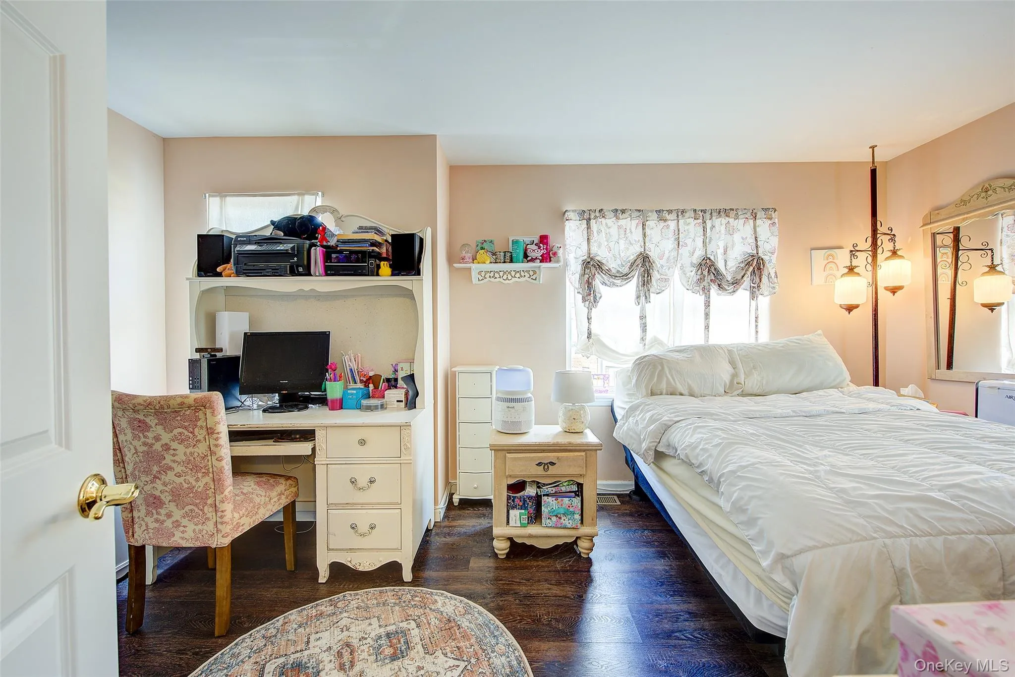 Bedroom featuring multiple windows, dark wood finished floors, and an office area Bedroom featuring multiple windows, dark wood finished floors, and an office area