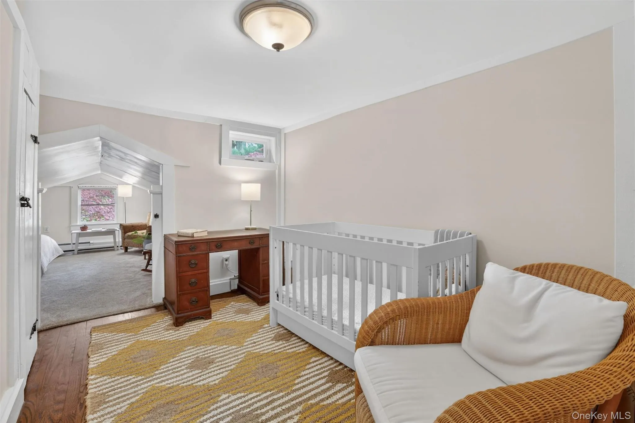 sitting room being with a crib and bedroom beyond sitting room being with a crib and bedroom beyond