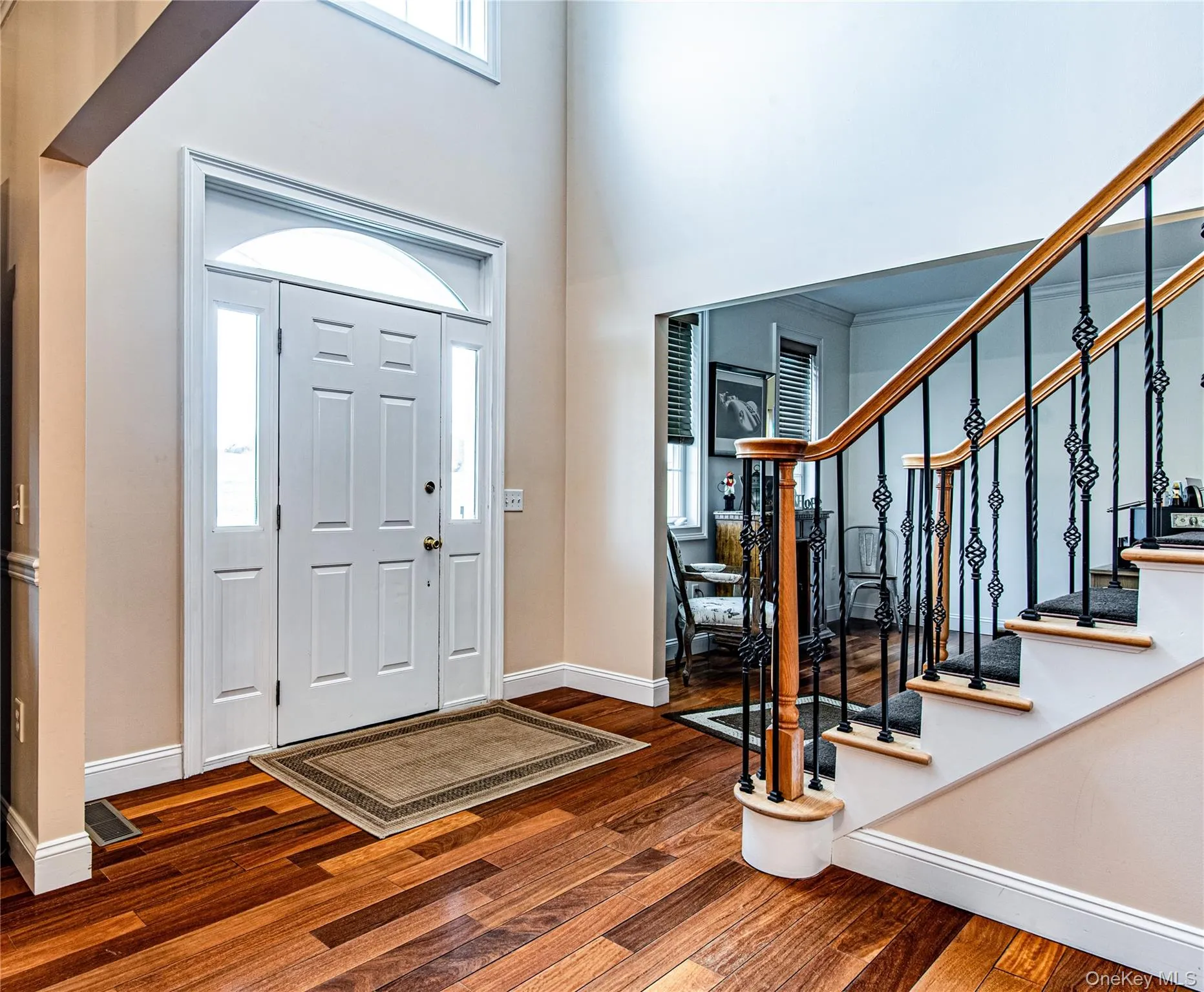 Foyer entrance featuring dark wood finished floors and a high ceiling Foyer entrance featuring dark wood finished floors and a high ceiling