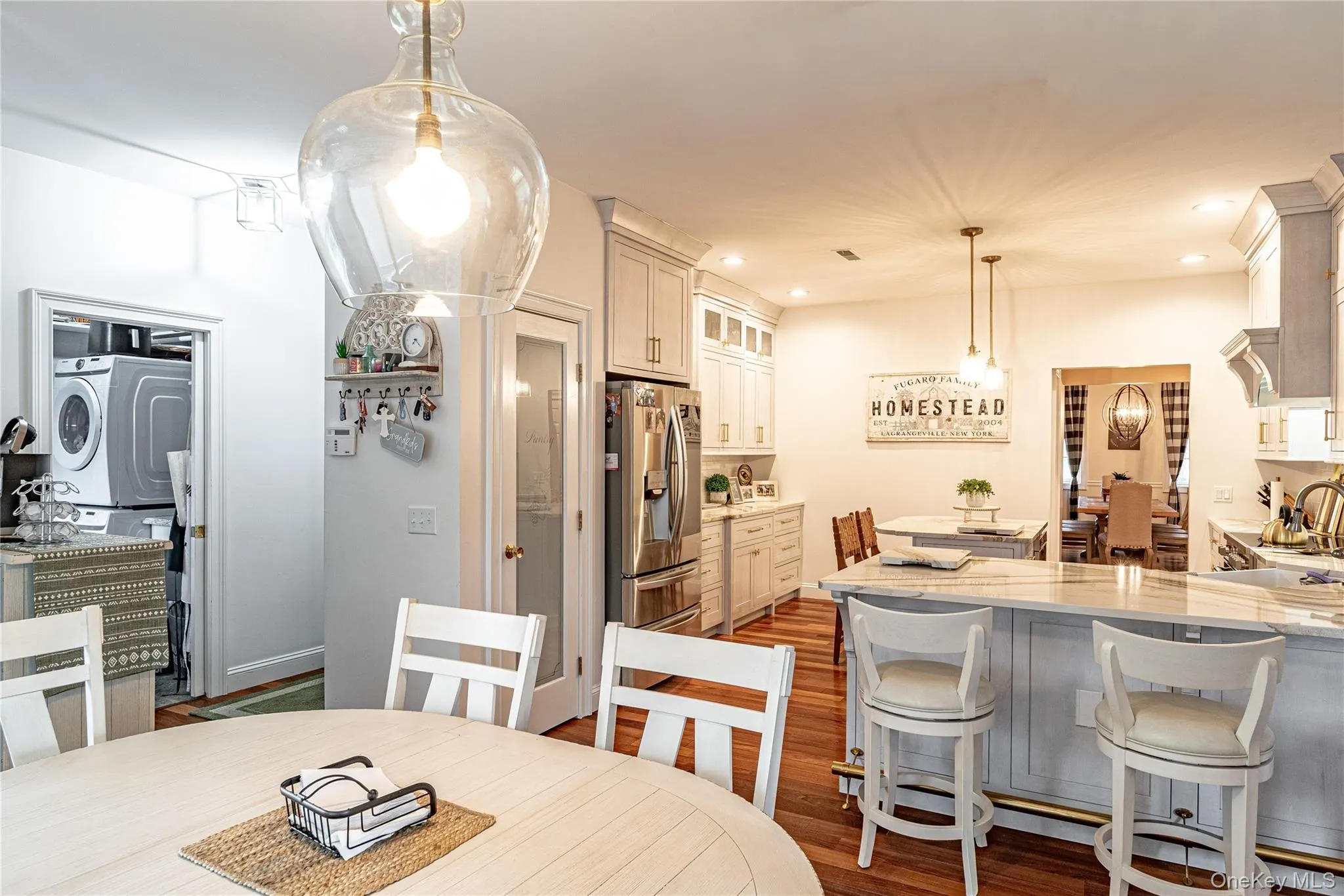 View of kitchen and laundry areas featuring dark wood-style floors, and recessed lighting View of kitchen and laundry areas featuring dark wood-style floors, and recessed lighting
