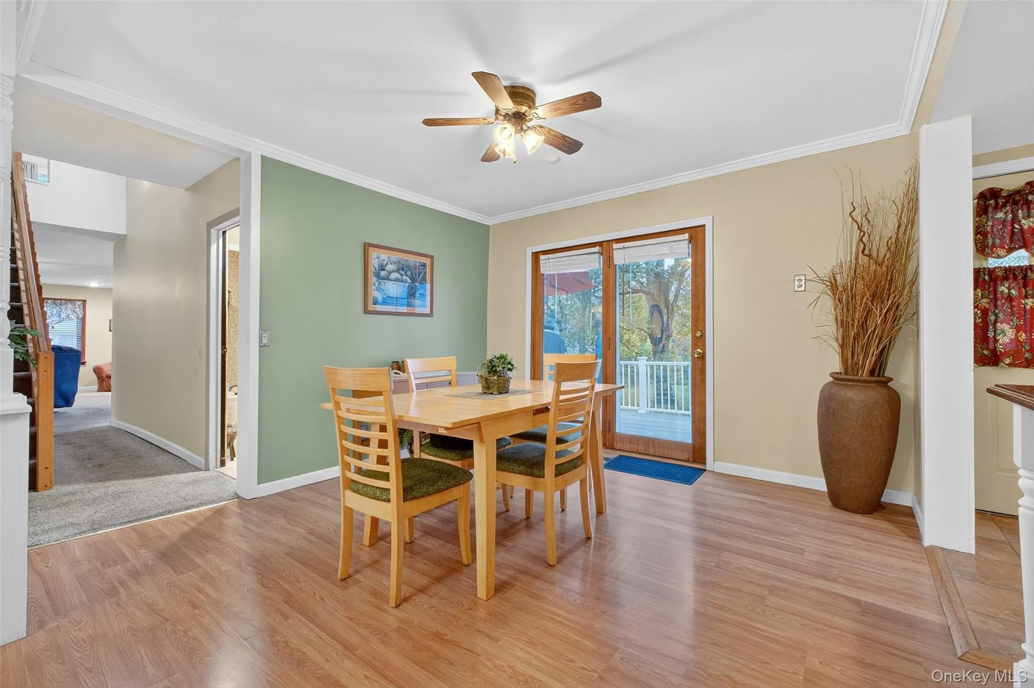 Dining space with light wood-style floors, ornamental molding, and a ceiling fan Dining space with light wood-style floors, ornamental molding, and a ceiling fan