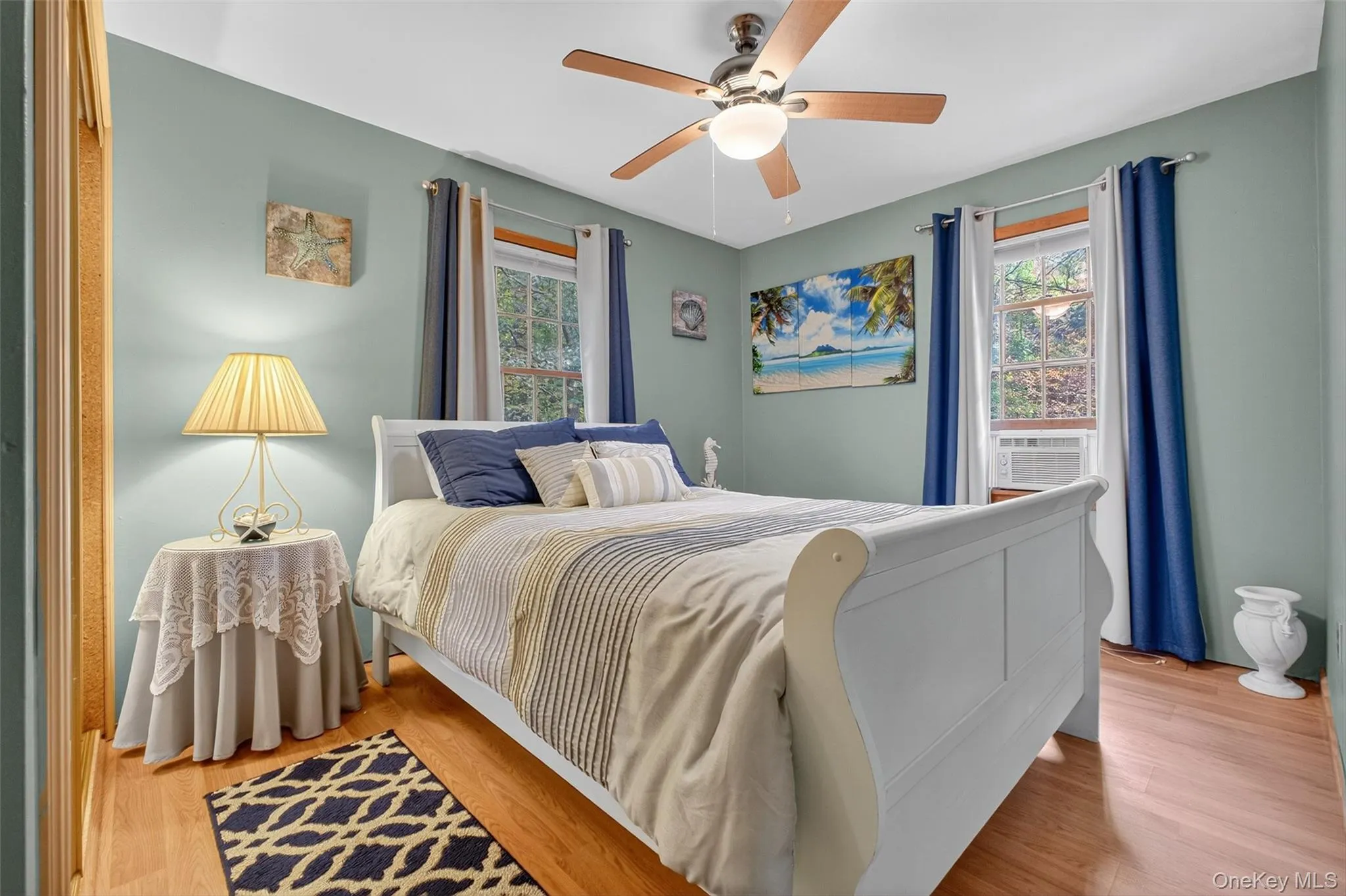Bedroom featuring light wood-type flooring, a ceiling fan, and cooling unit Bedroom featuring light wood-type flooring, a ceiling fan, and cooling unit