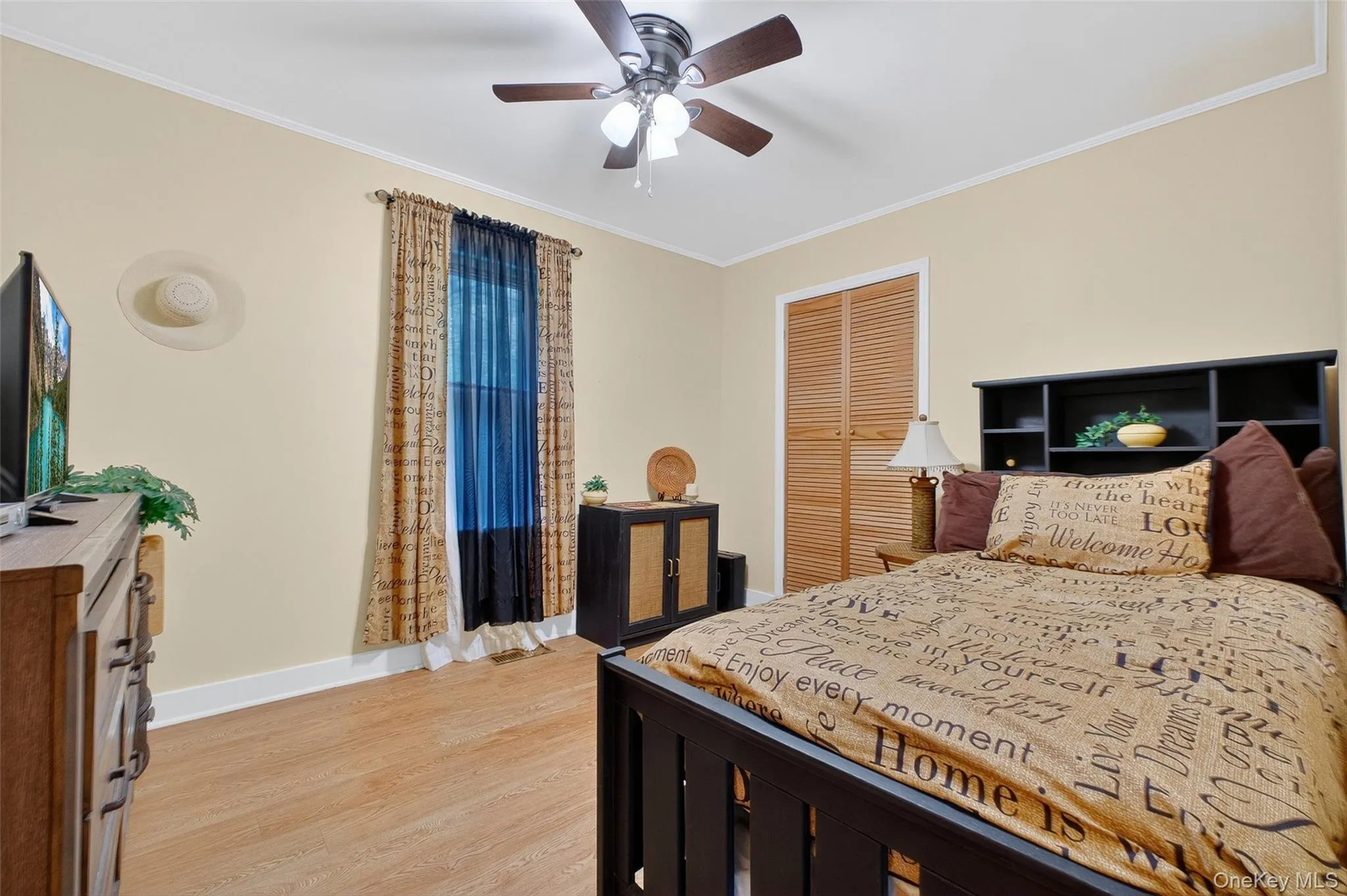 Bedroom featuring crown molding, light wood finished floors, a closet, and ceiling fan Bedroom featuring crown molding, light wood finished floors, a closet, and ceiling fan