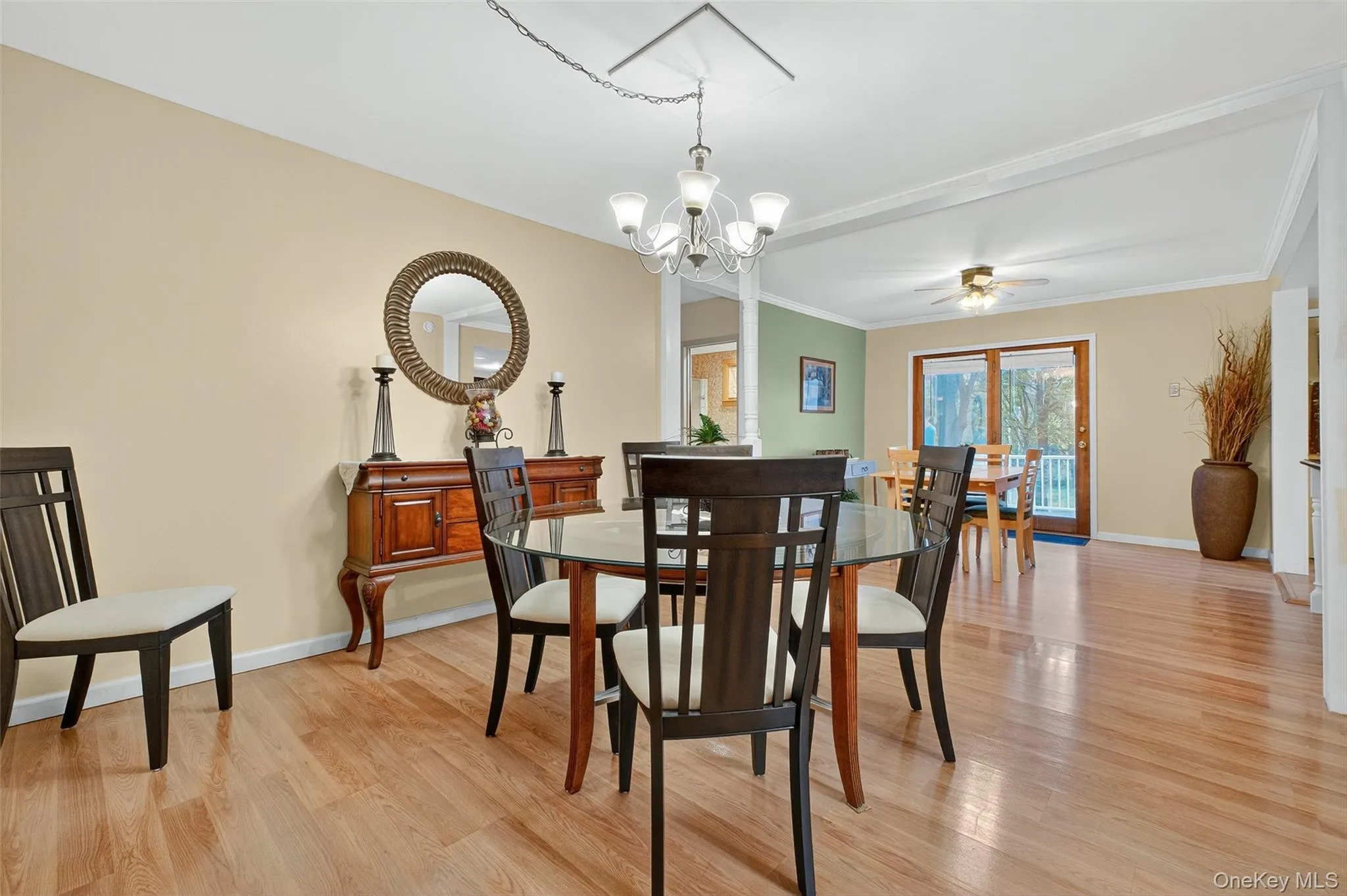 Dining area featuring light wood-type flooring, ceiling fan, a chandelier, and crown molding Dining area featuring light wood-type flooring, ceiling fan, a chandelier, and crown molding