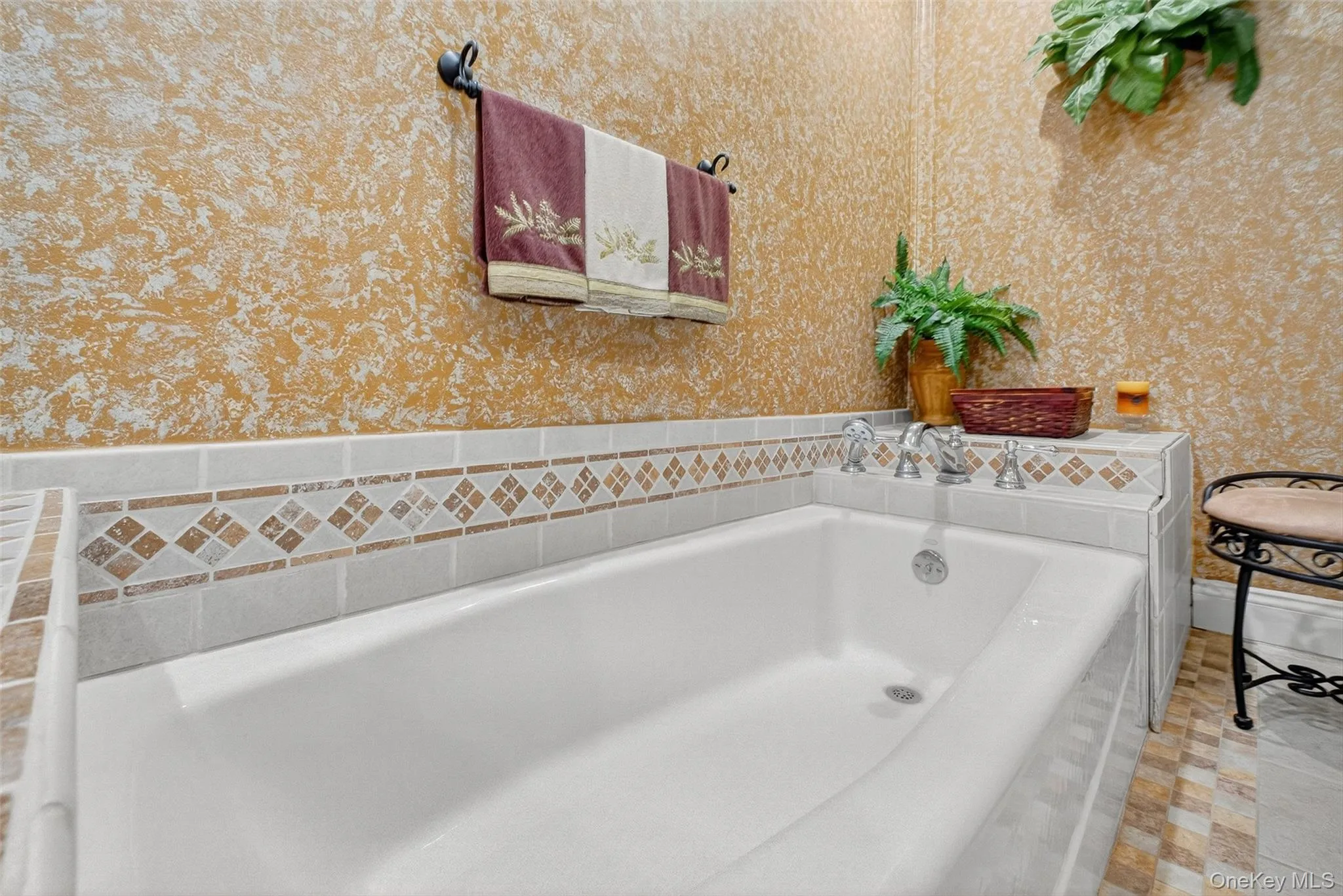 Full bathroom featuring a bath and wallpapered walls Full bathroom featuring a bath and wallpapered walls